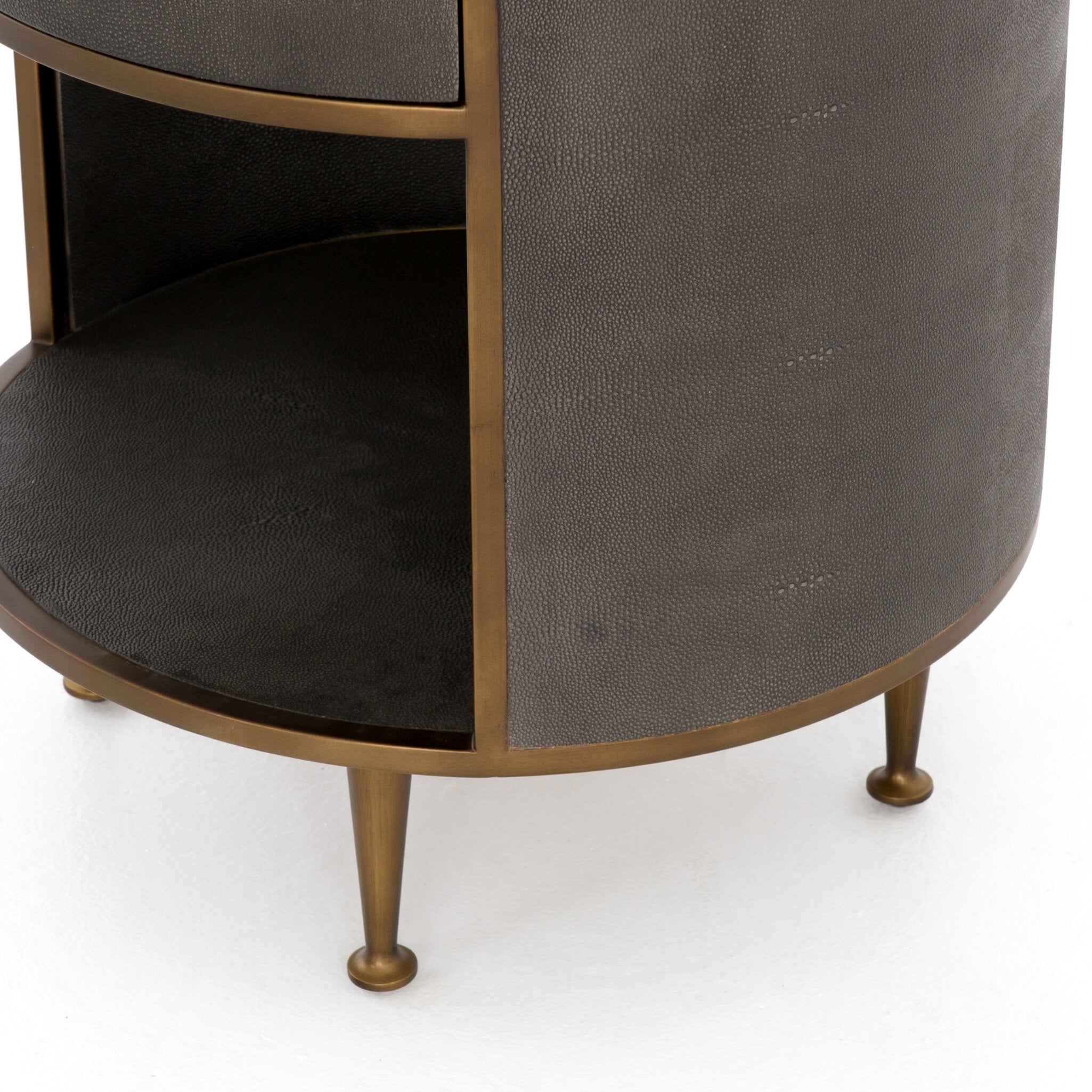 Round nightstand with a drawer and bronze legs on a white background.