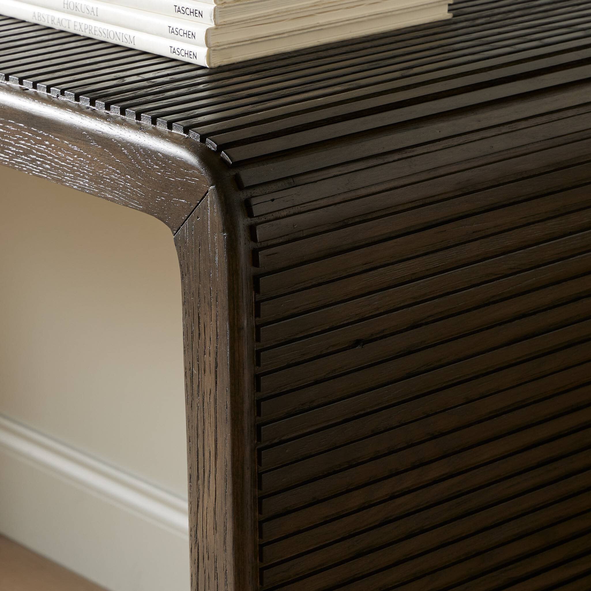 Close-up of a dark wooden console table with a stack of books on top.