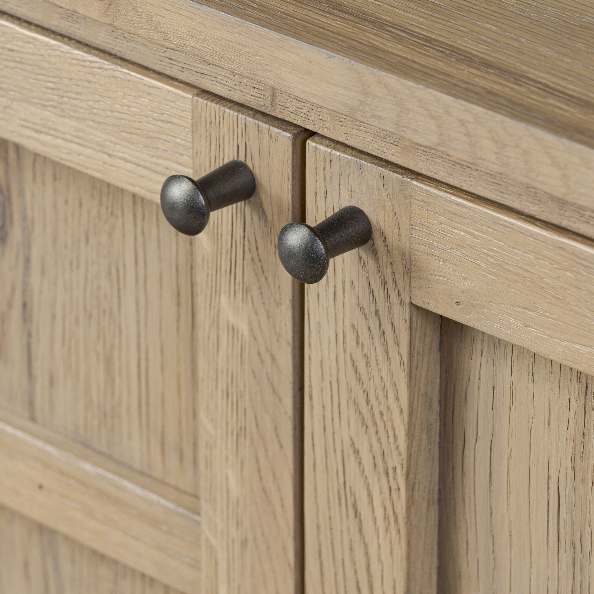 Close up of a wood sideboard with a grid like pattern on the doors on a white background.
