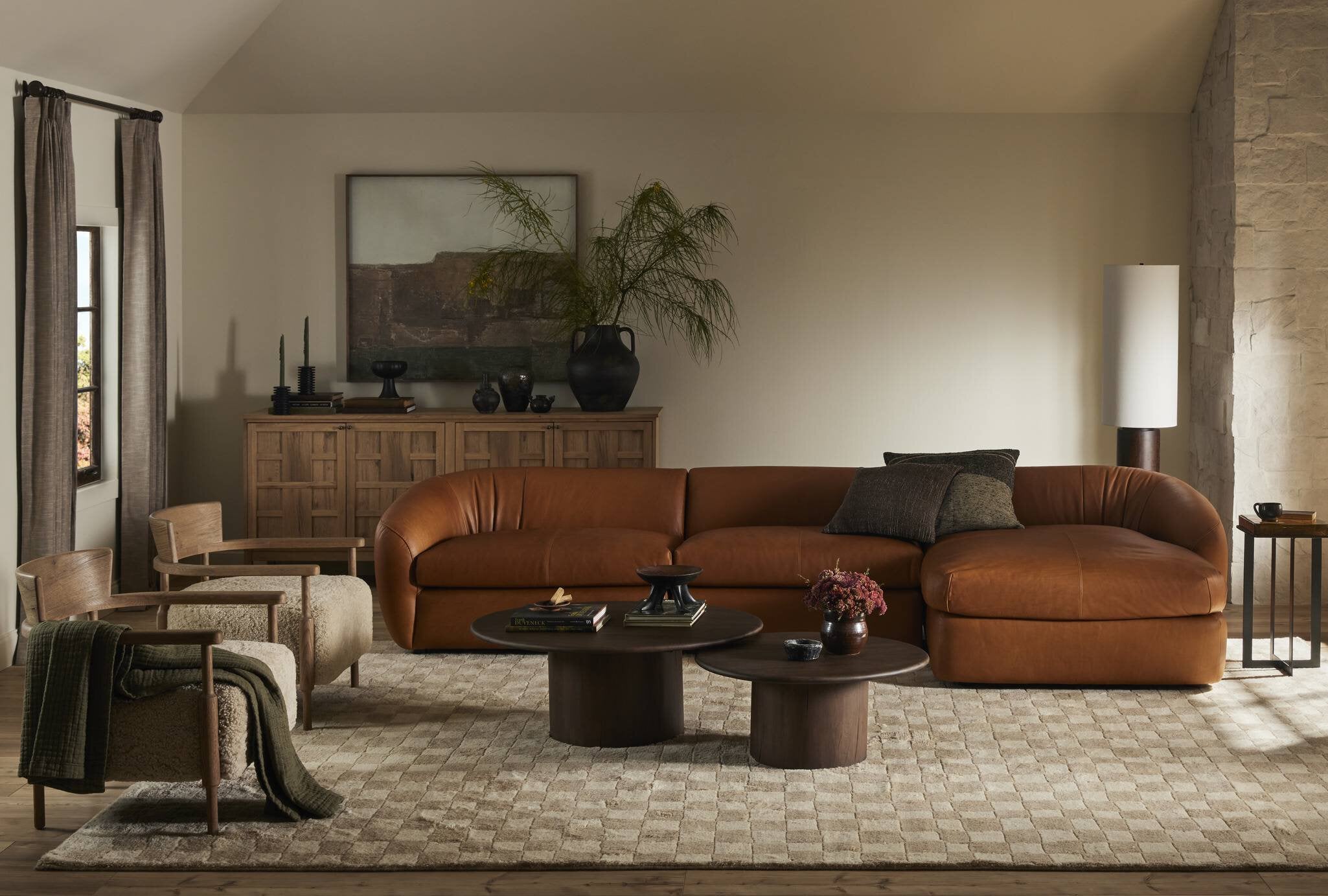 Cozy living room with a brown leather sectional sofa, wooden coffee table, and decorative items.
