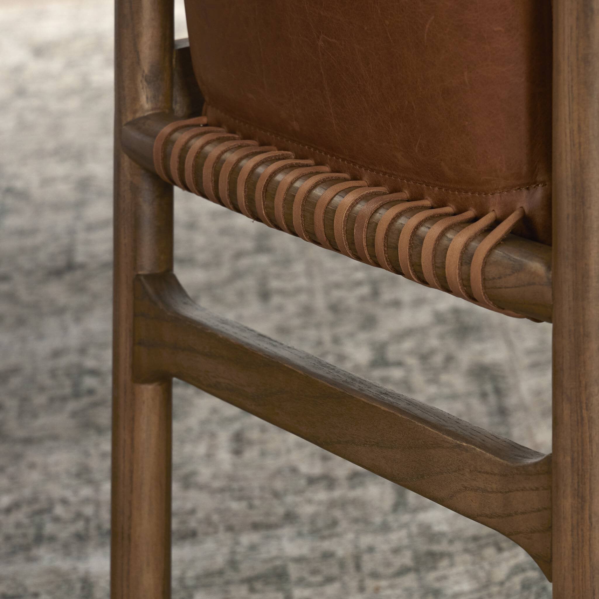 Close up of a tobacco-grain leather chair highlighting its leather wrap detailing.