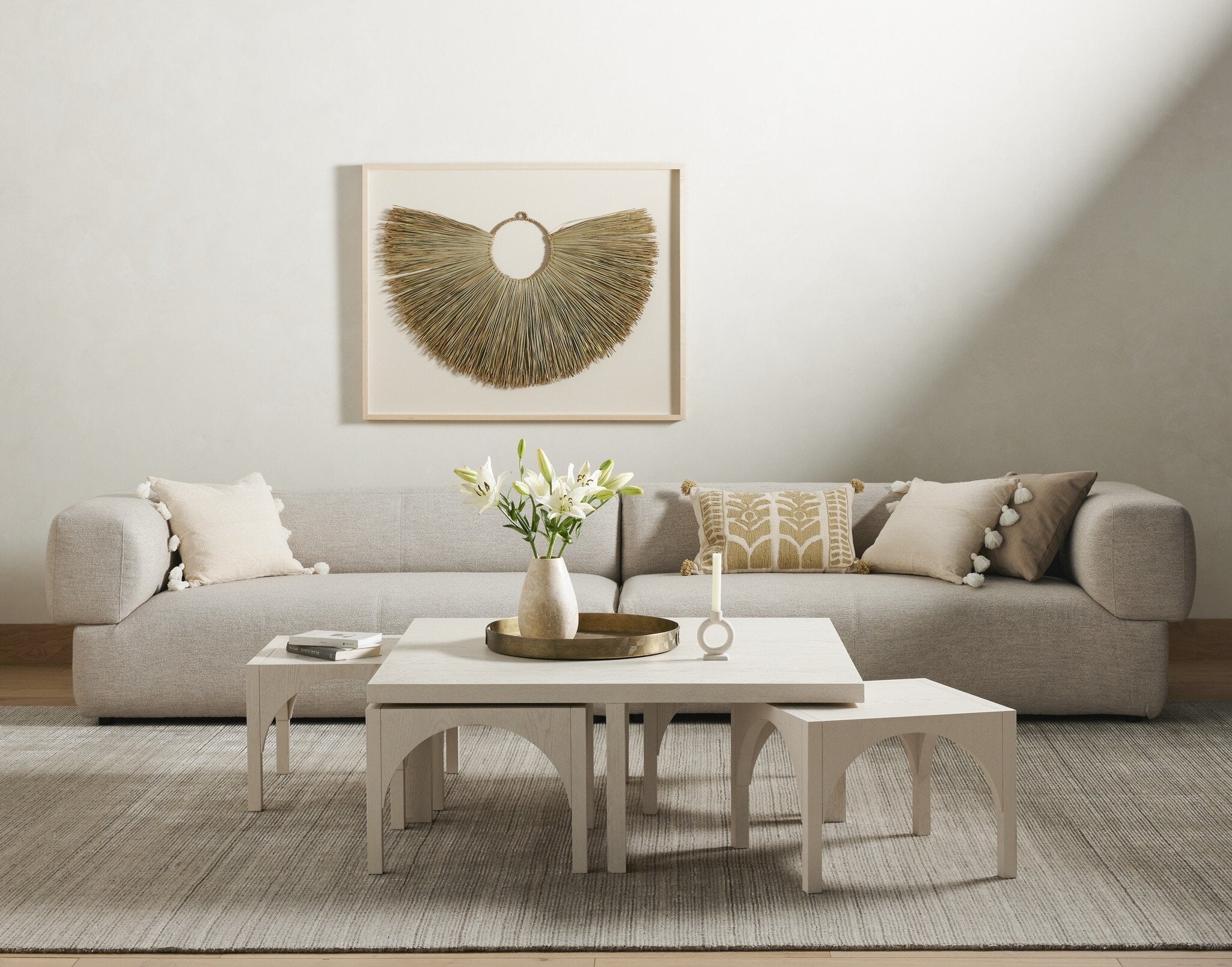 Modern living room with a beige sofa, coffee table, and decorative elements.