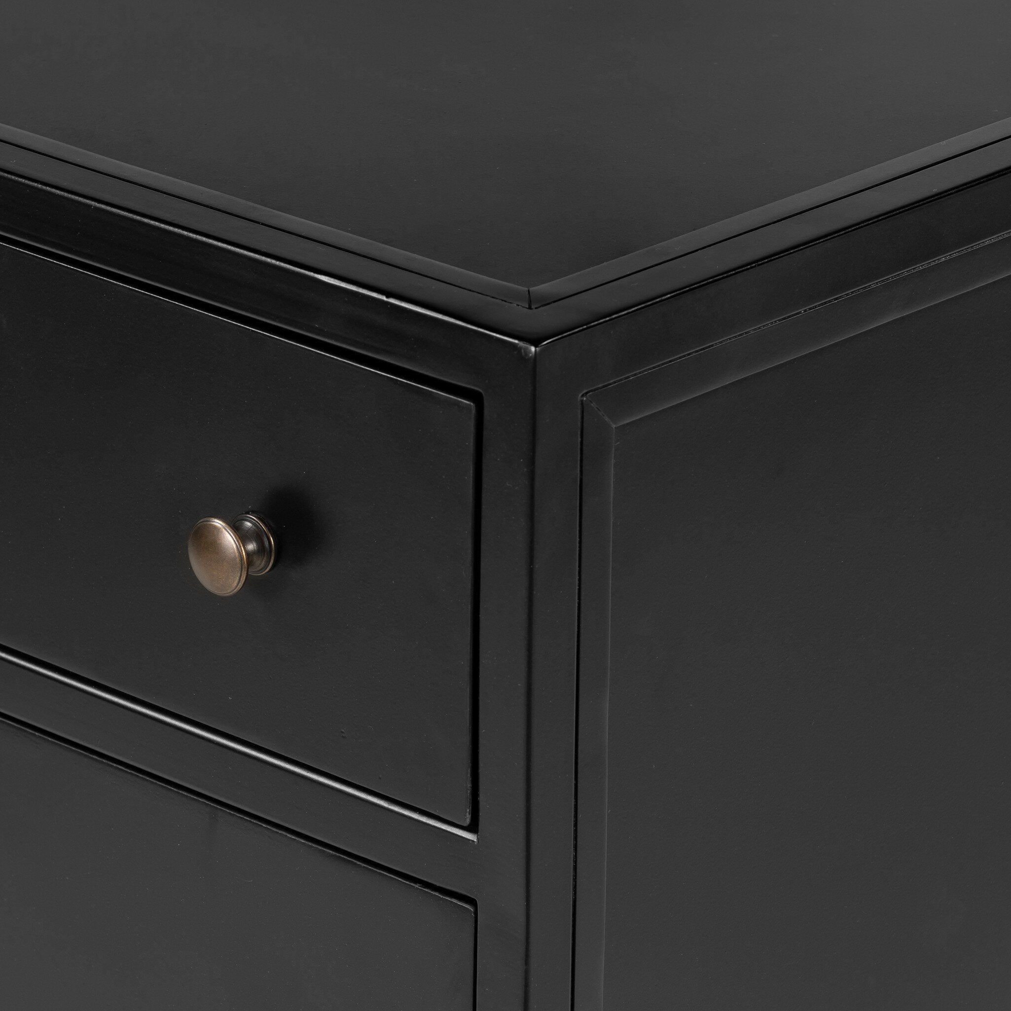 A black dresser with three drawers and metallic knobs on a white background.