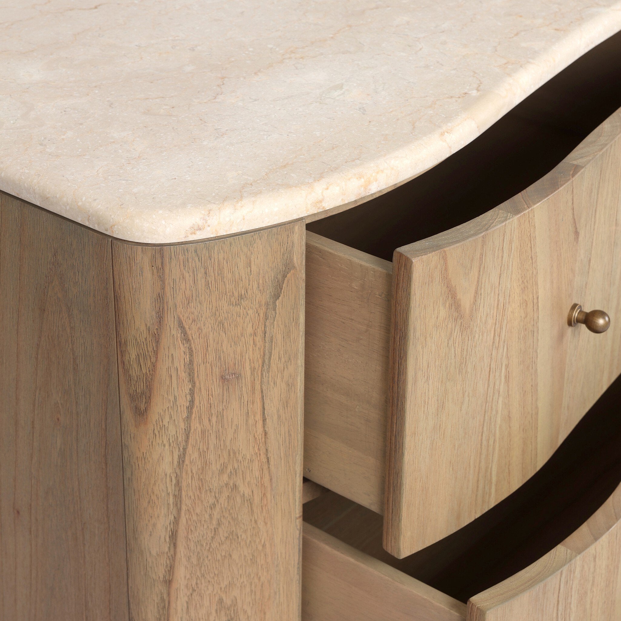 Close up of a wooden dresser with six drawers and topped with cream-white marble on a white background.