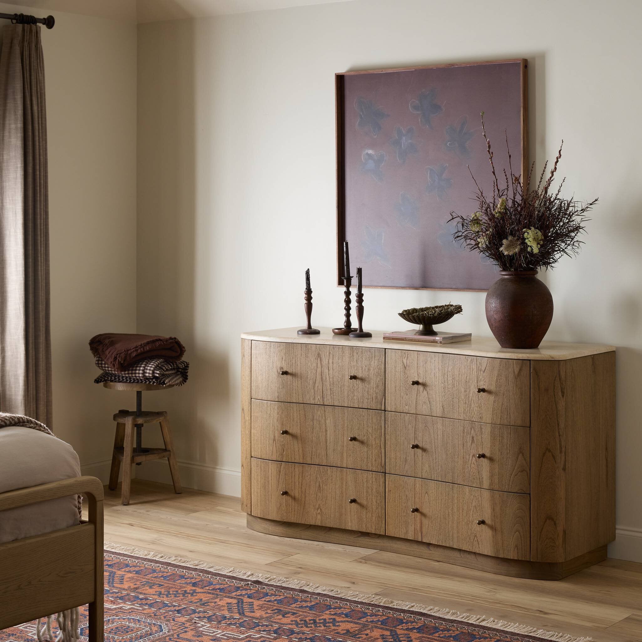 Wooden dresser with decorative items in a bedroom setting
