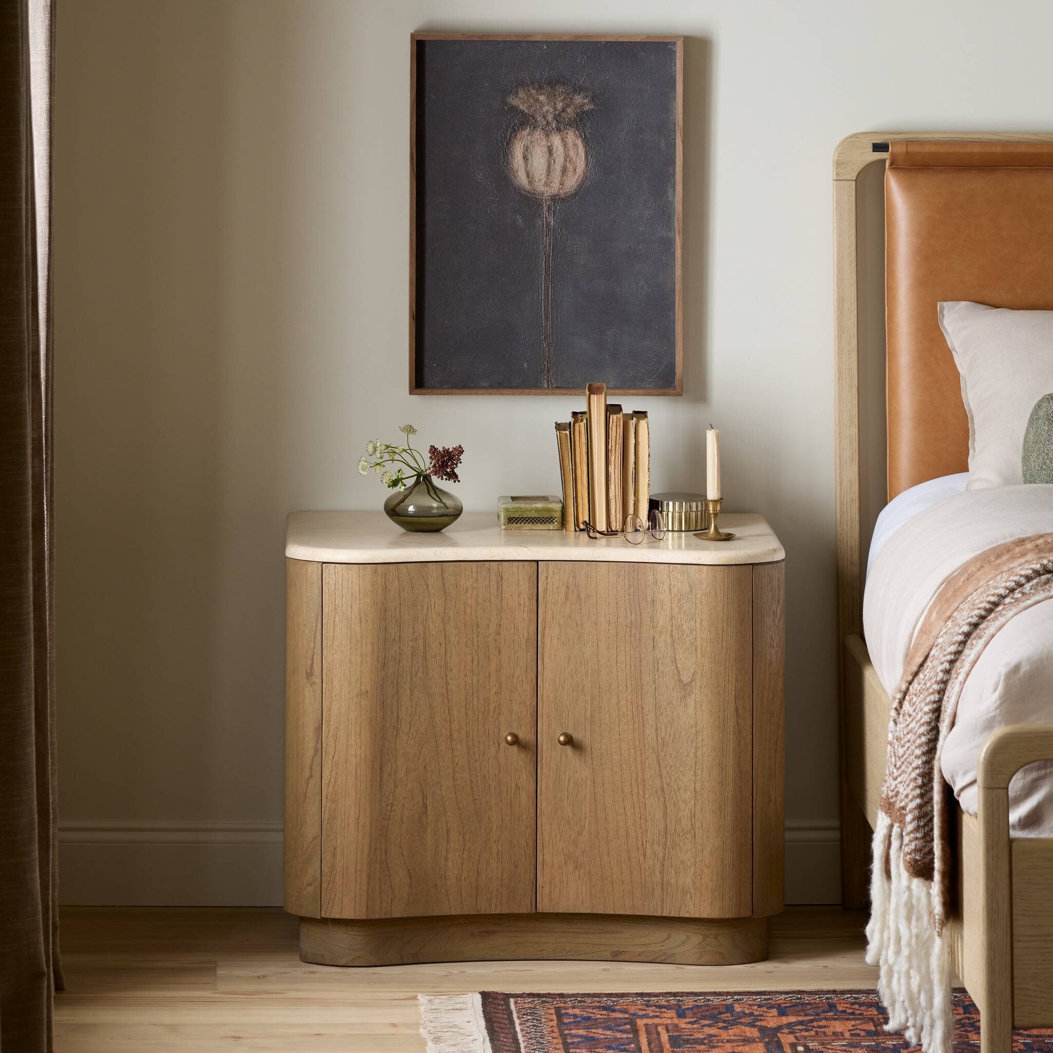 Wooden side table with decorative items in a bedroom setting.