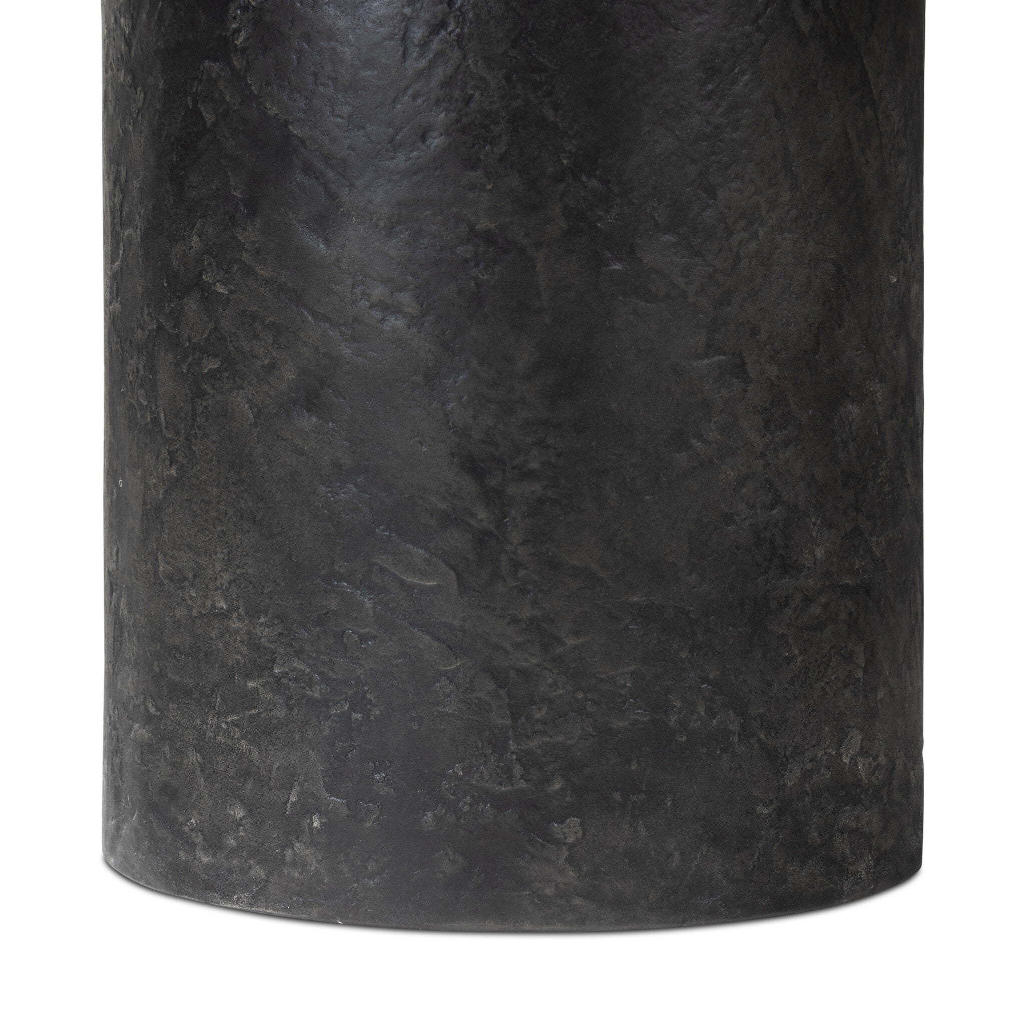 Close up of a round black concrete dining table on a white background.