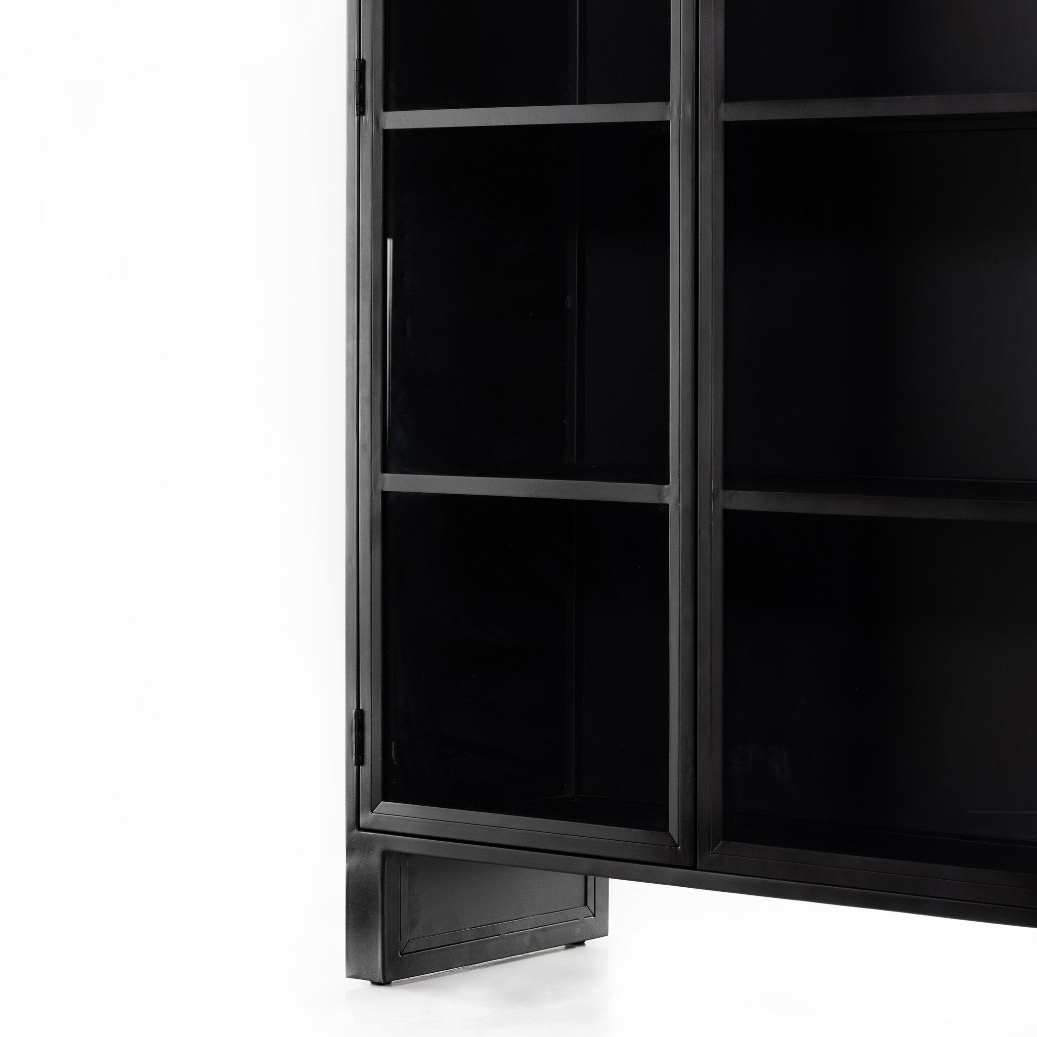 Close up of a black-finished iron arched cabinet with glass front doors.