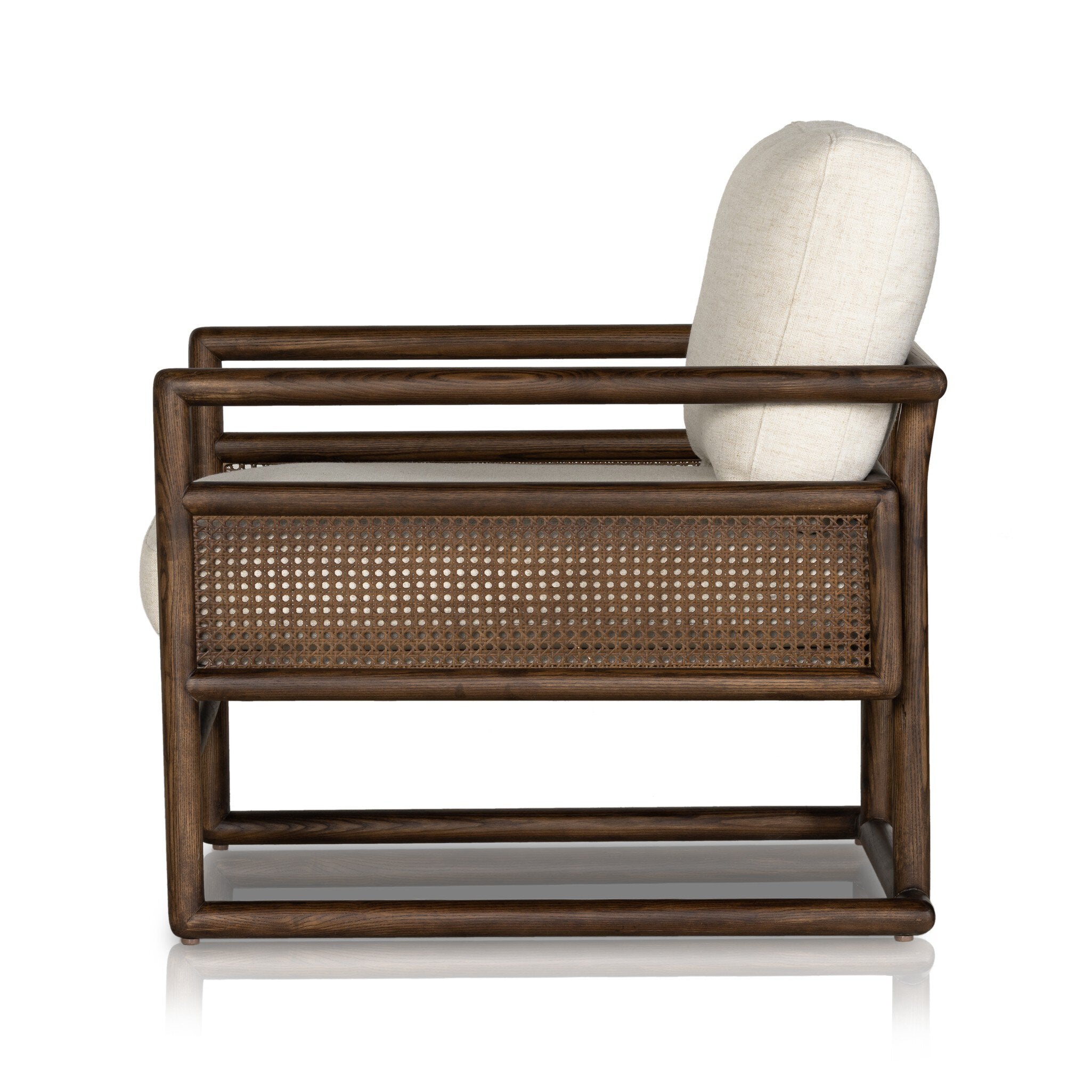 Side profile of a chair with neutral linen fabric, cane panels with open rounded framing.