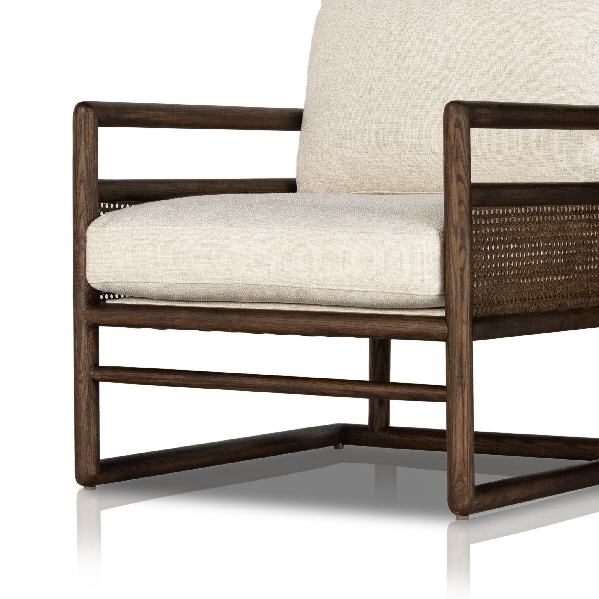 Chair with neutral linen fabric, cane panels with open rounded framing.