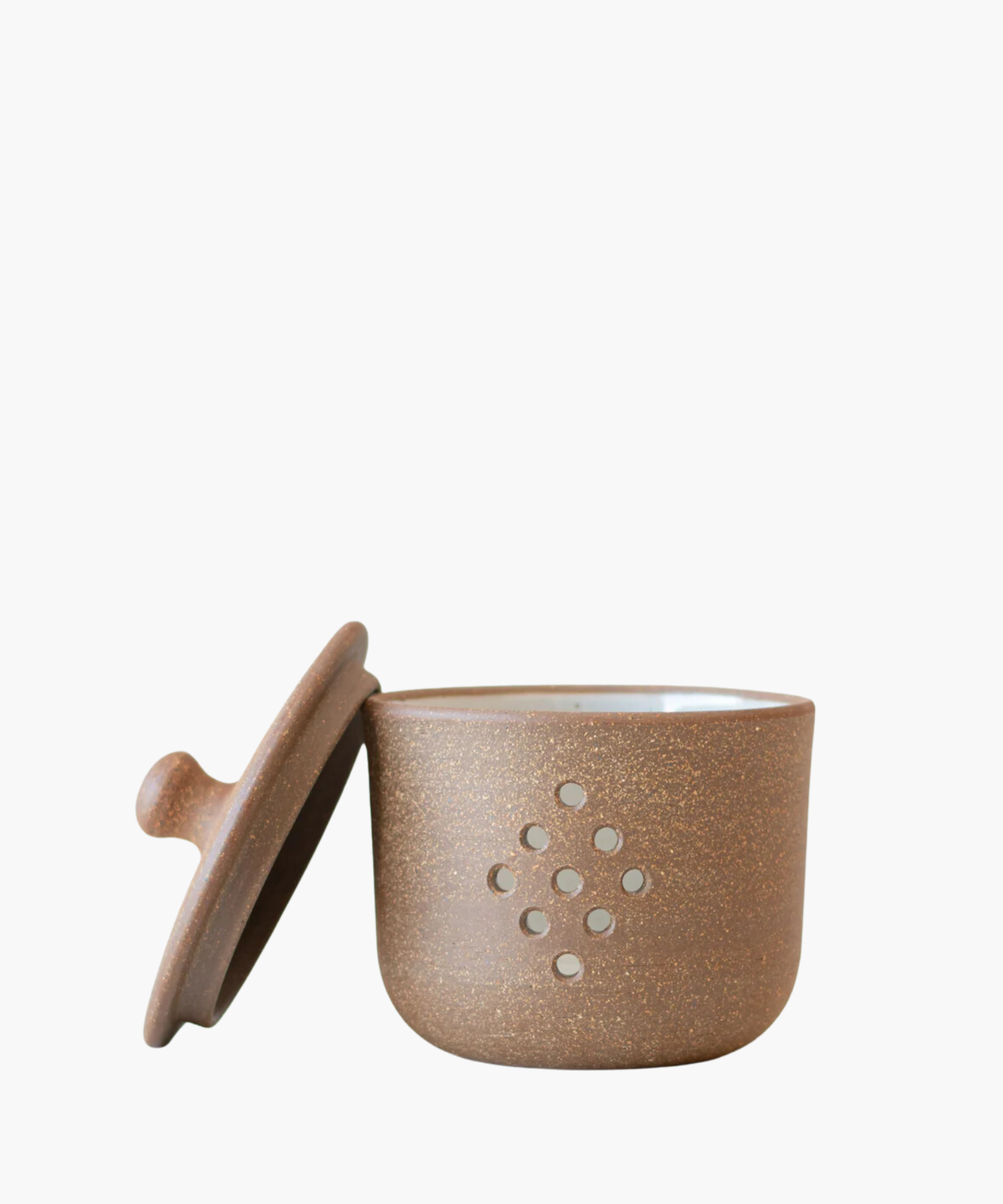 A round, speckled brown pottery garlic keeper with a fitted lid, featuring nine ventilation holes in a diamond pattern. The tone is rustic and earthy.