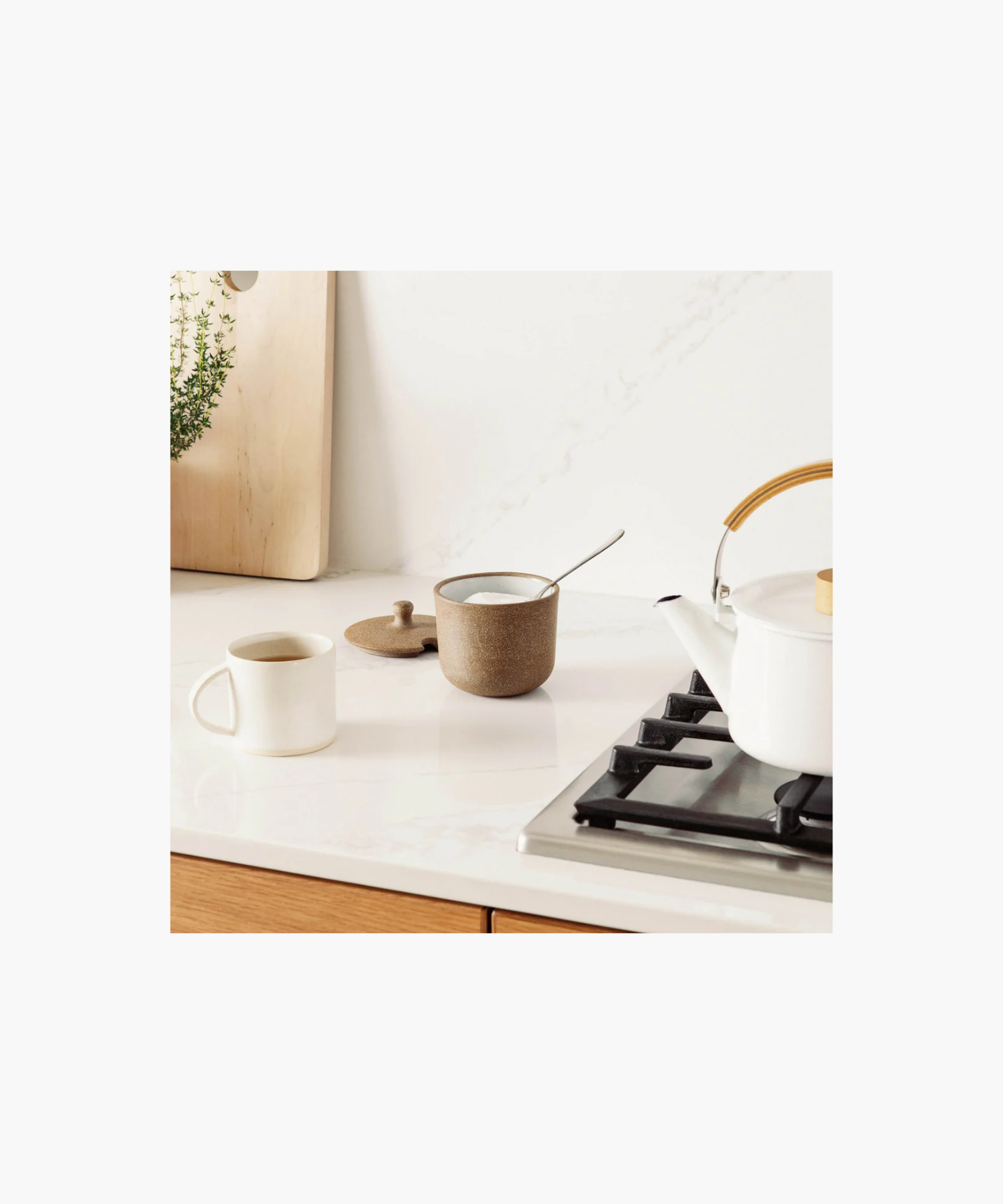 A rustic brown ceramic sugar jar with a speckled texture styled with sugar and a cup of coffee conveying a cozy, earthy vibe.