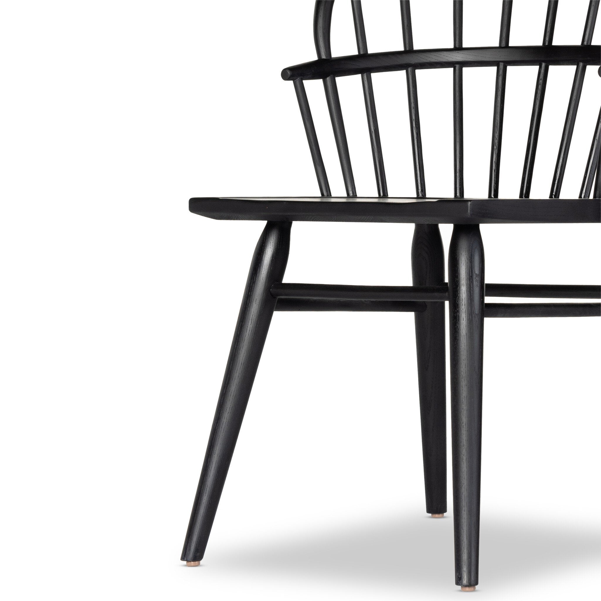 Close up of a black dining chair with a minimalist design on a white background.