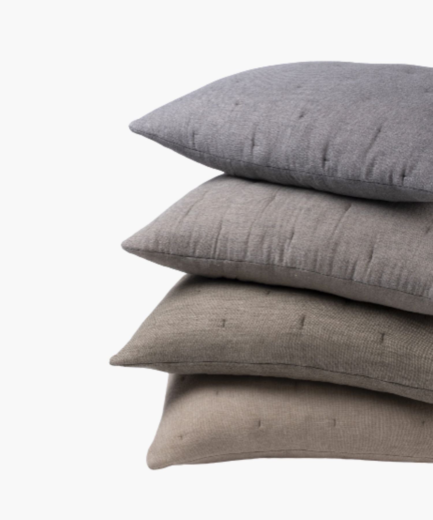 Stack pillows ranging from beige to grey on a light background.