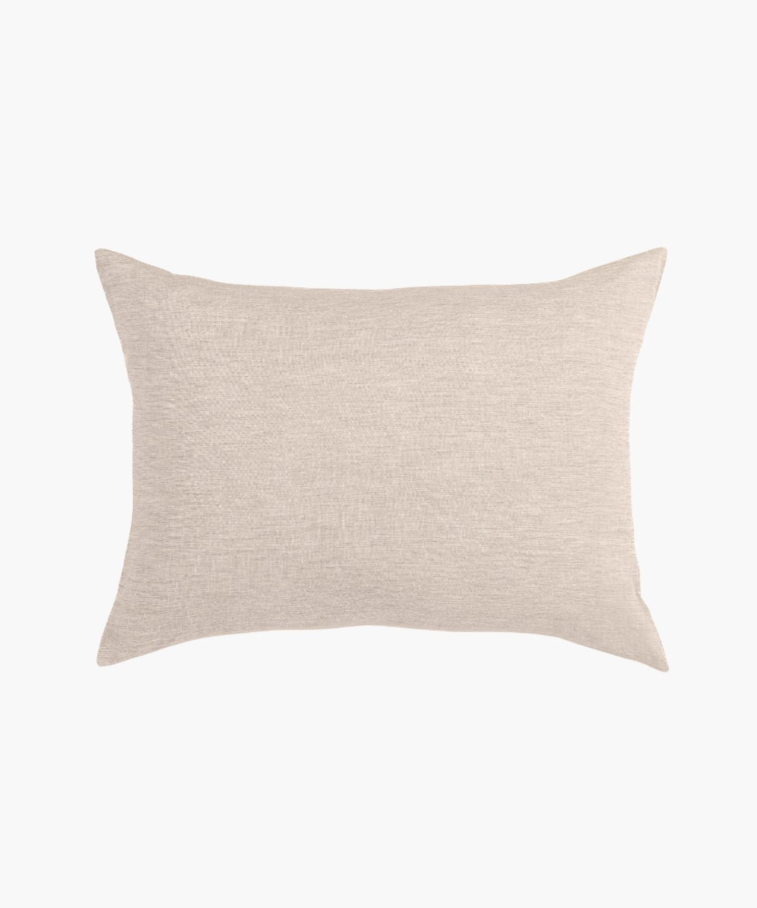 Pillow cover styled on a white background, showing knife edge or flange detailing, fabric texture, and muted palette.