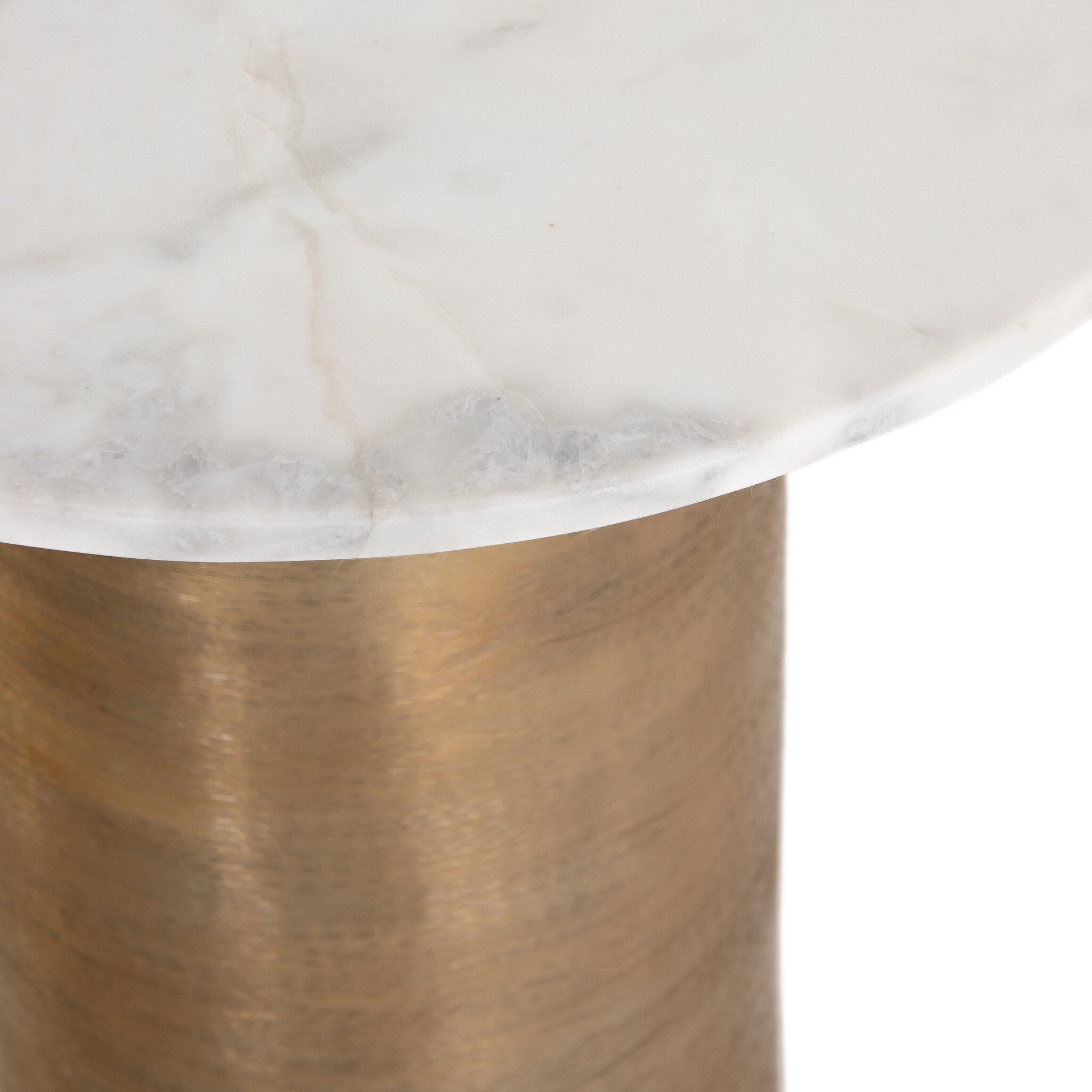 Close up of a nightstand with a brass base and a white marble on a white background.