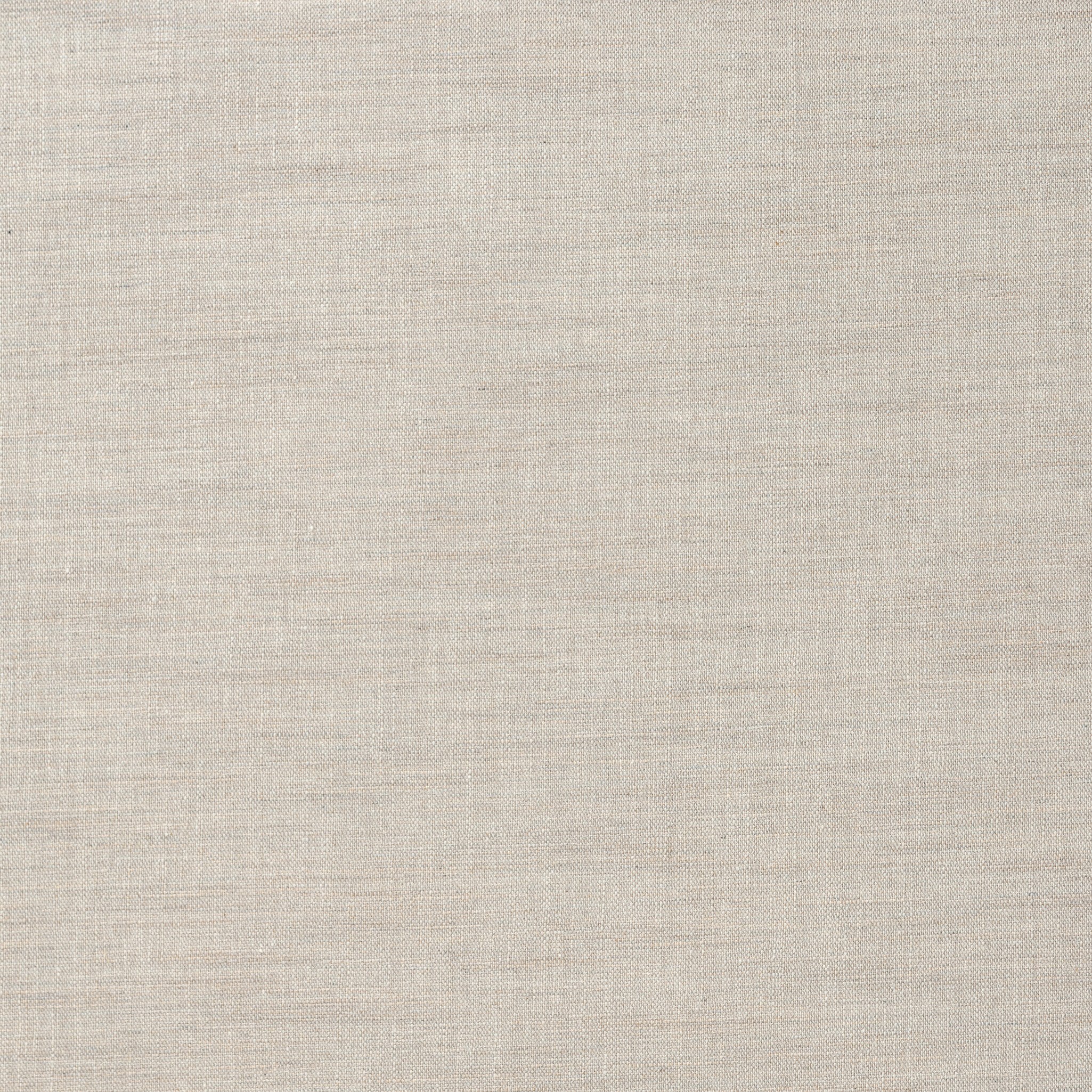 Close up of a heritage-inspired oak bed featuring soft curves, linen upholstered headboard, and white bedding on a white background.