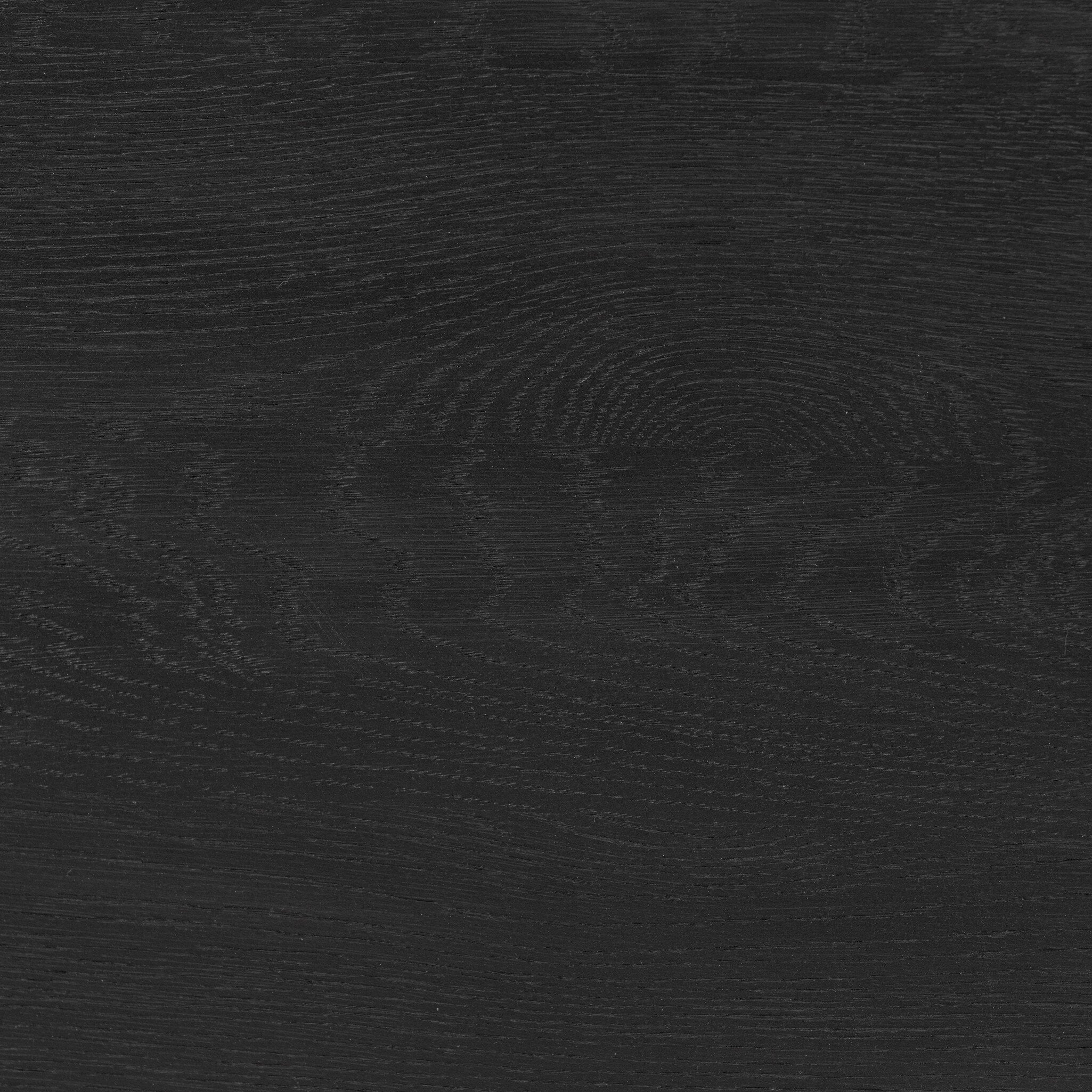 Close up of the coffee table showing its black color and wood grain.