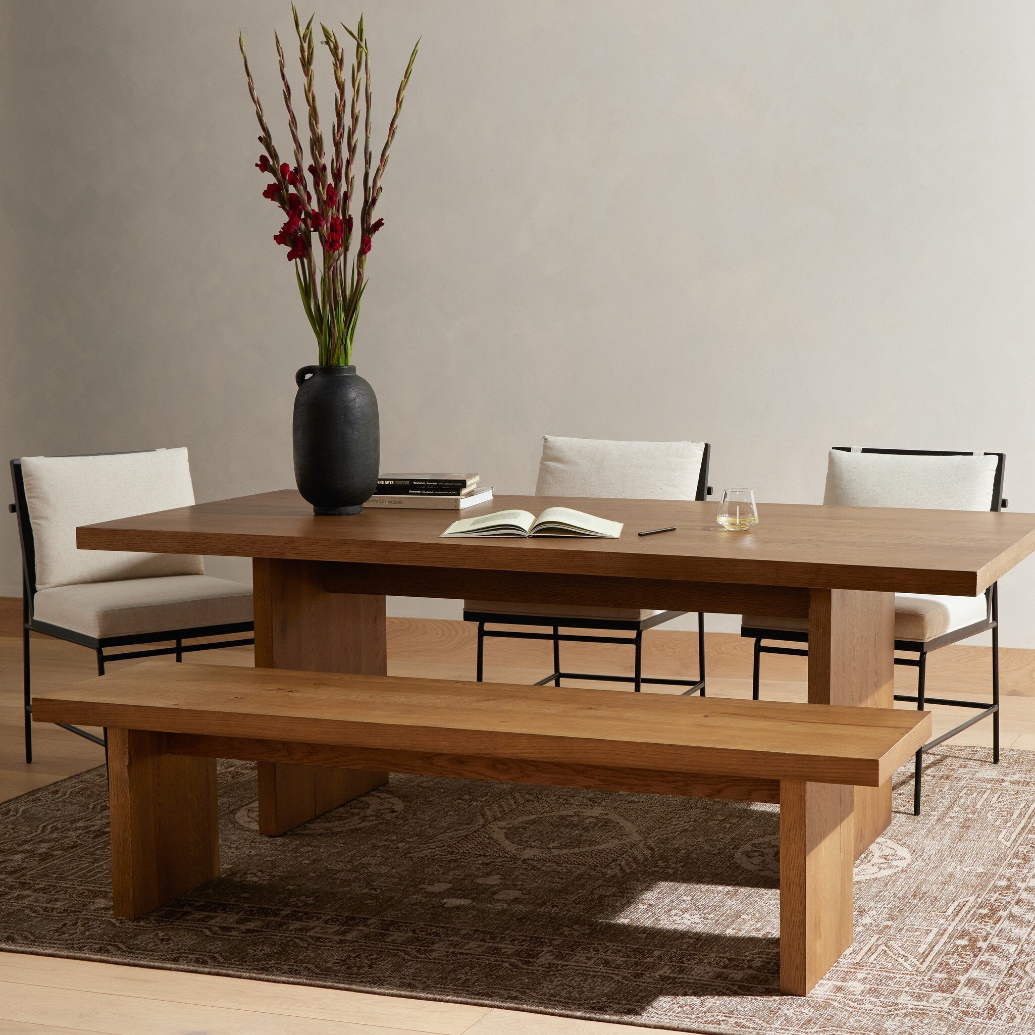 Wooden dining table with bench and chairs in a room setting