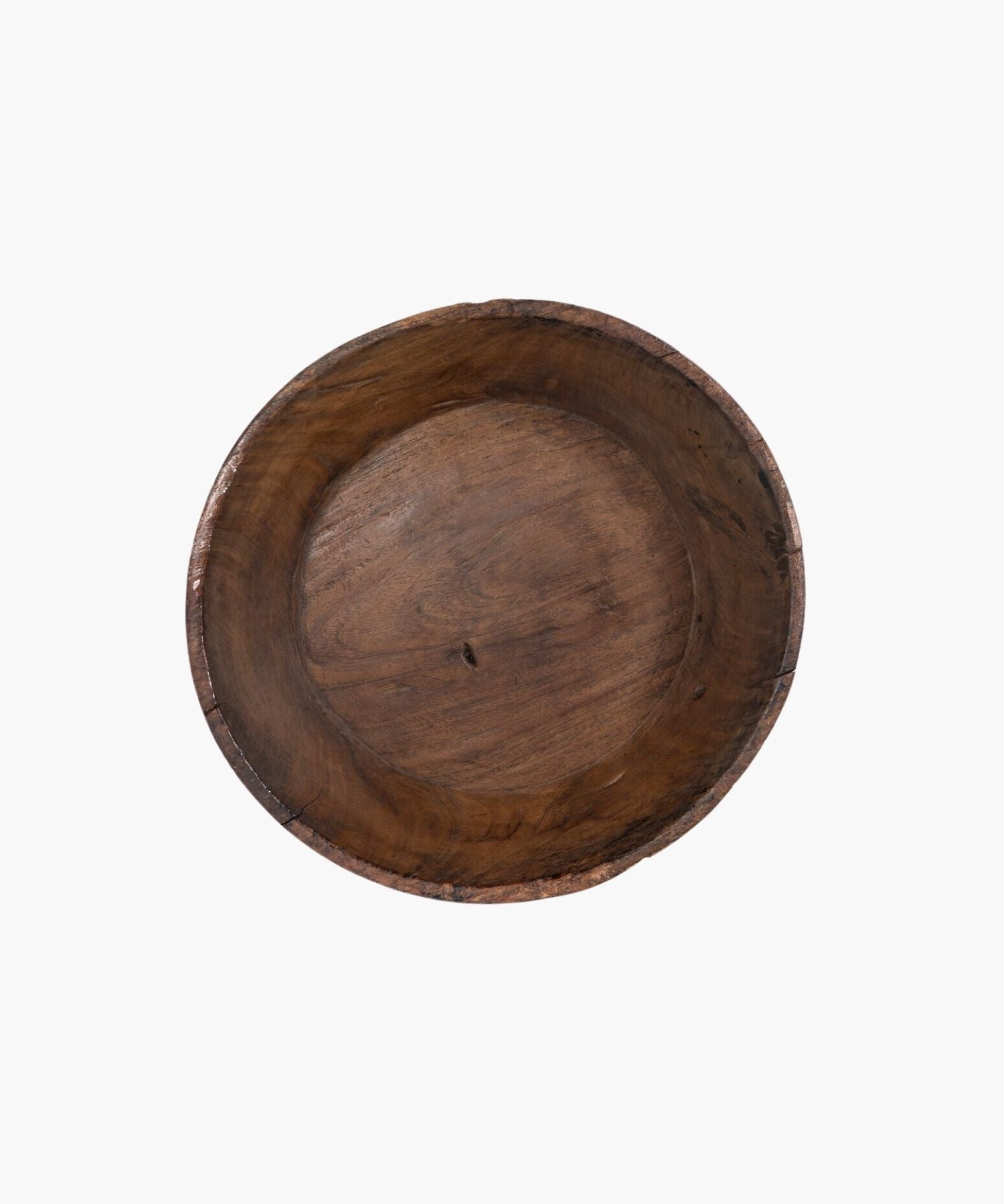 Overhead view of a large rustic wooden bowl with a smooth, rounded interior and rough, textured exterior. The natural grain and earthy tones suggest simplicity and warmth.