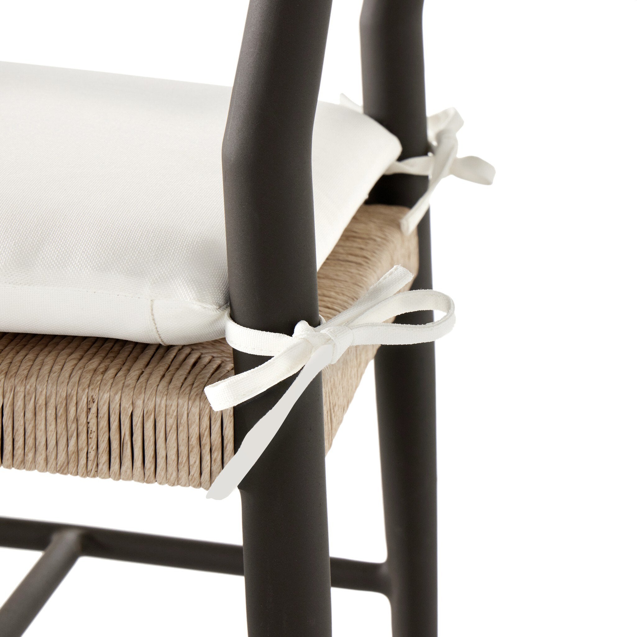 Close up of a classic ladderback outdoor dining chair with a woven seat and removable cushion.