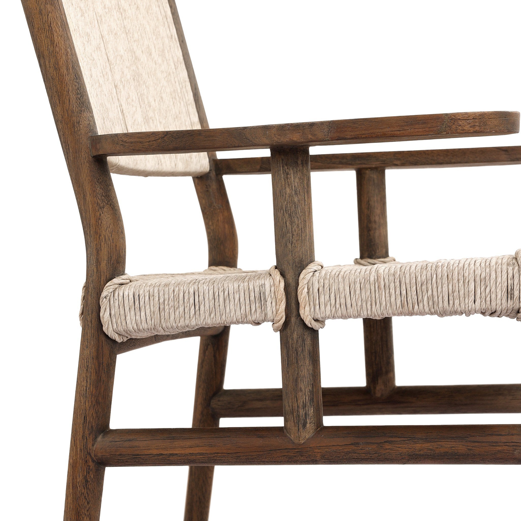 Close up side profile view of a shaker style outdoor dining armchair with a dark brown wood frame and light brown woven seat and back on a white background.