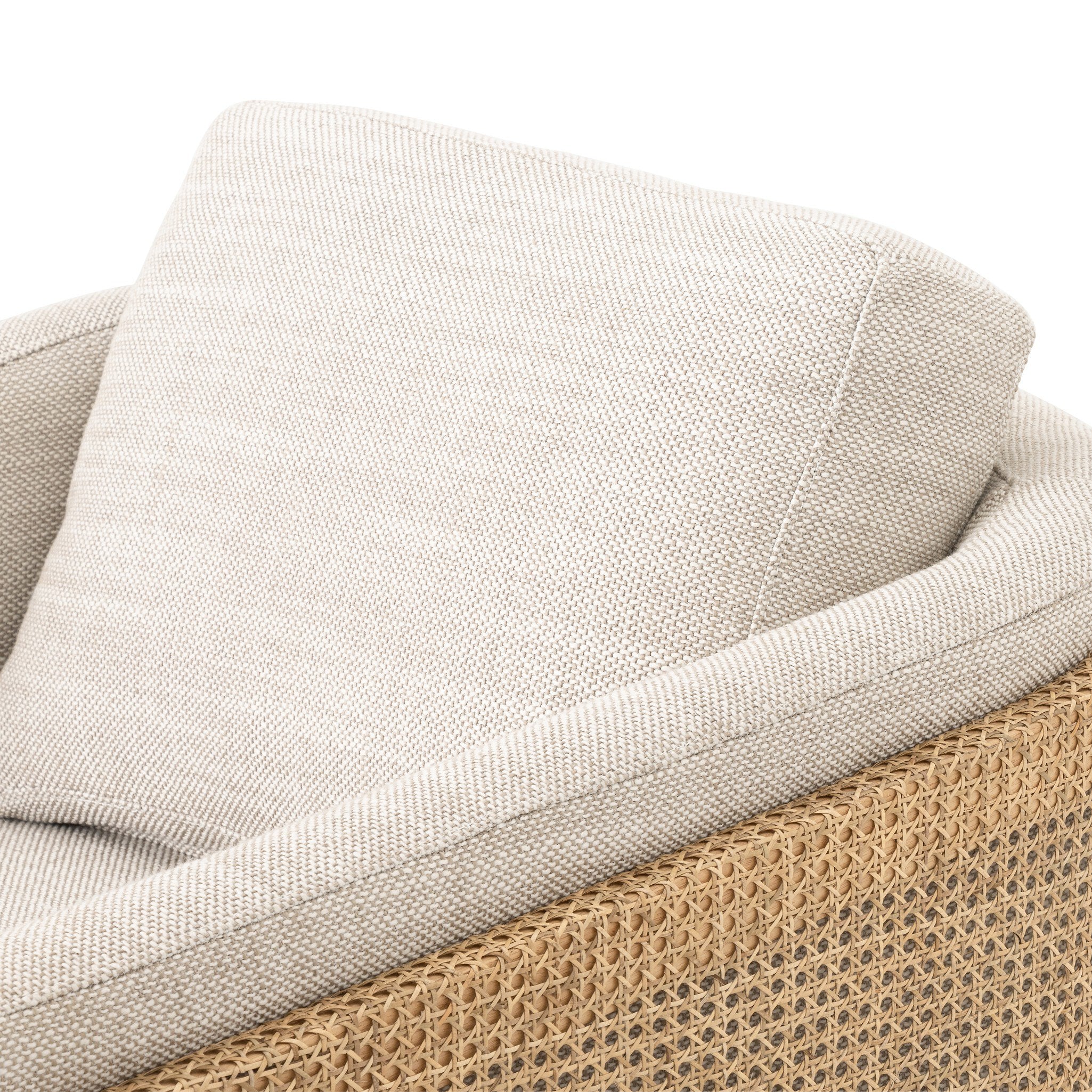 Close up of a beige armchair with dark metal legs on a white background.