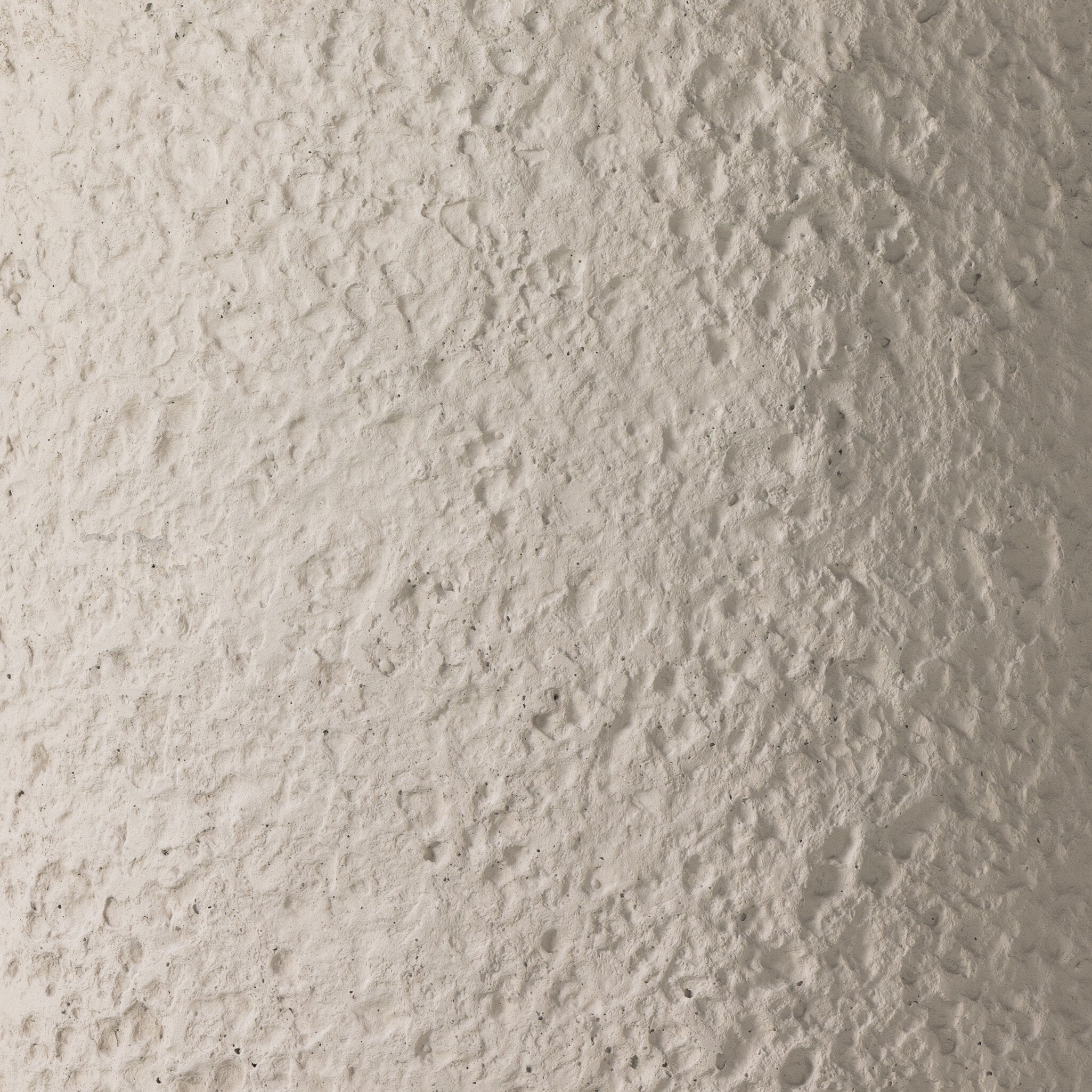 Close up of the pumice concrete coffee table showing its heavy texture and gray color.