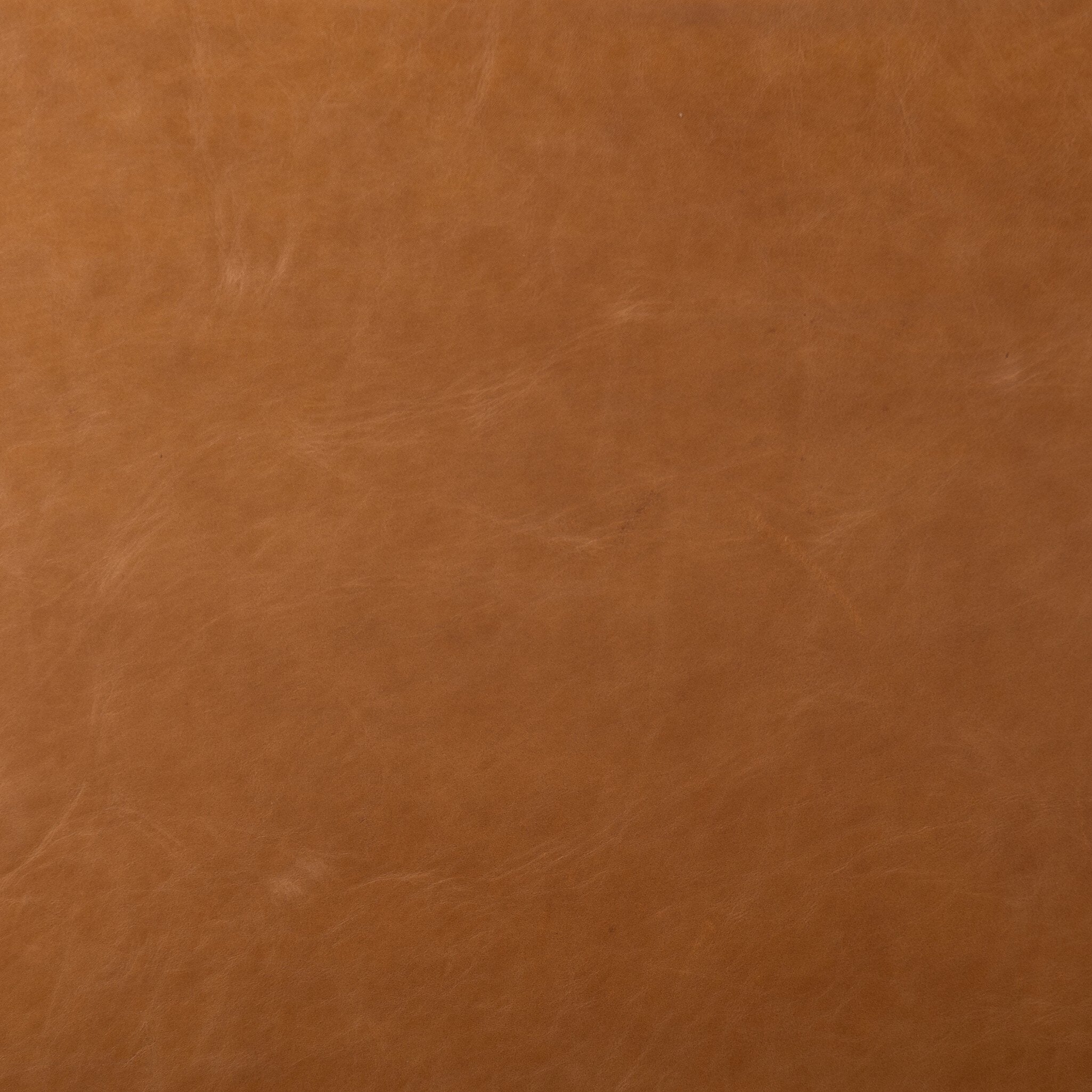 Close up of a brown wooden chair with sling-style leather seating on a white background.