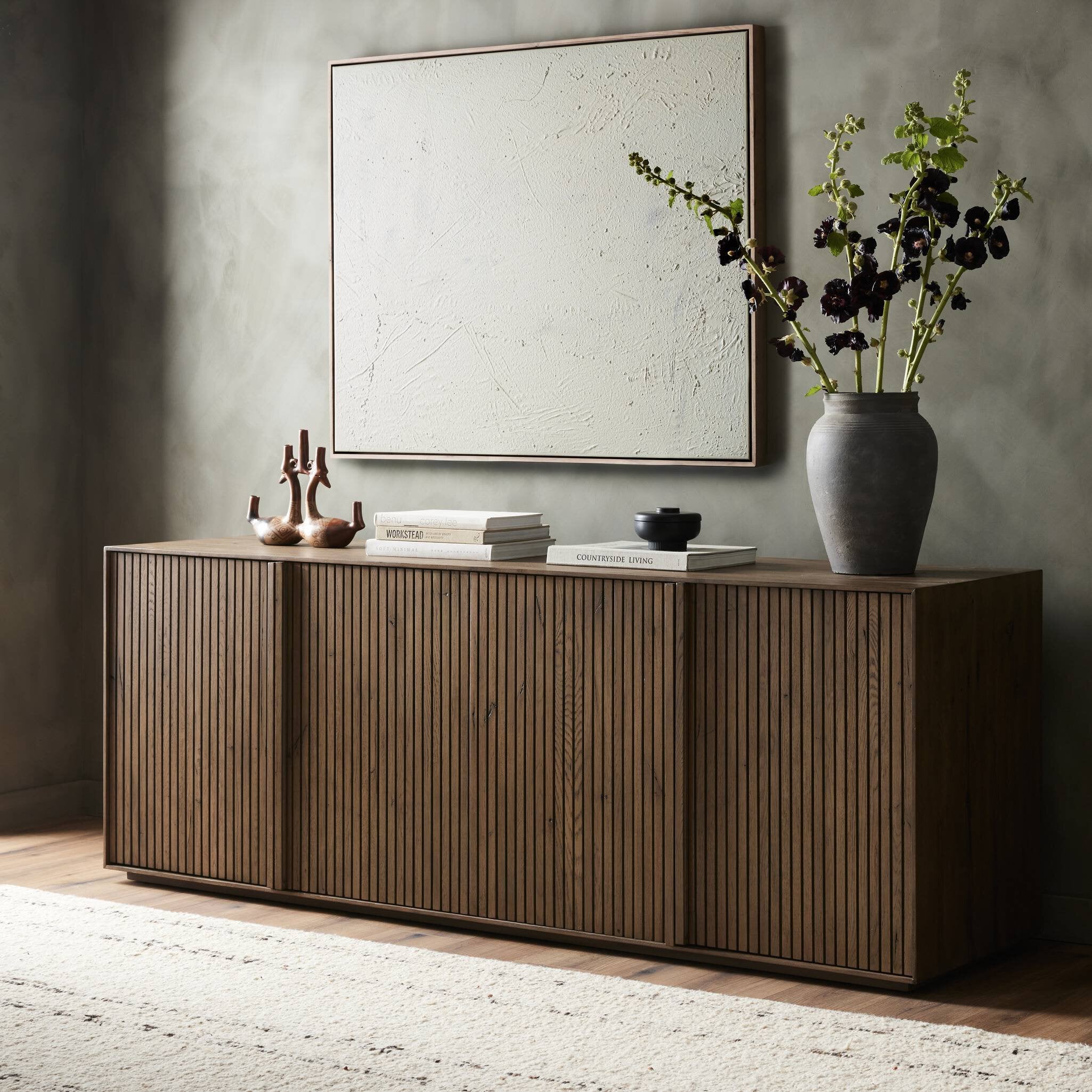 Wooden sideboard with decorative items against a gray wall