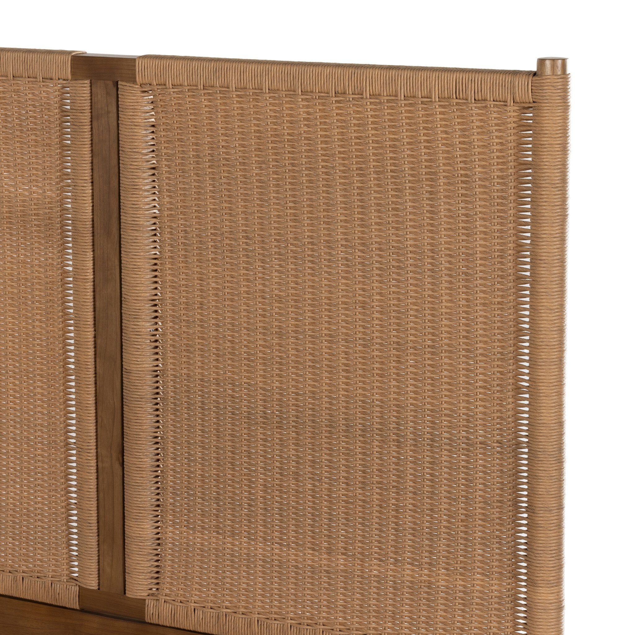 Close up of a wicker bed with white bedding on a white background.