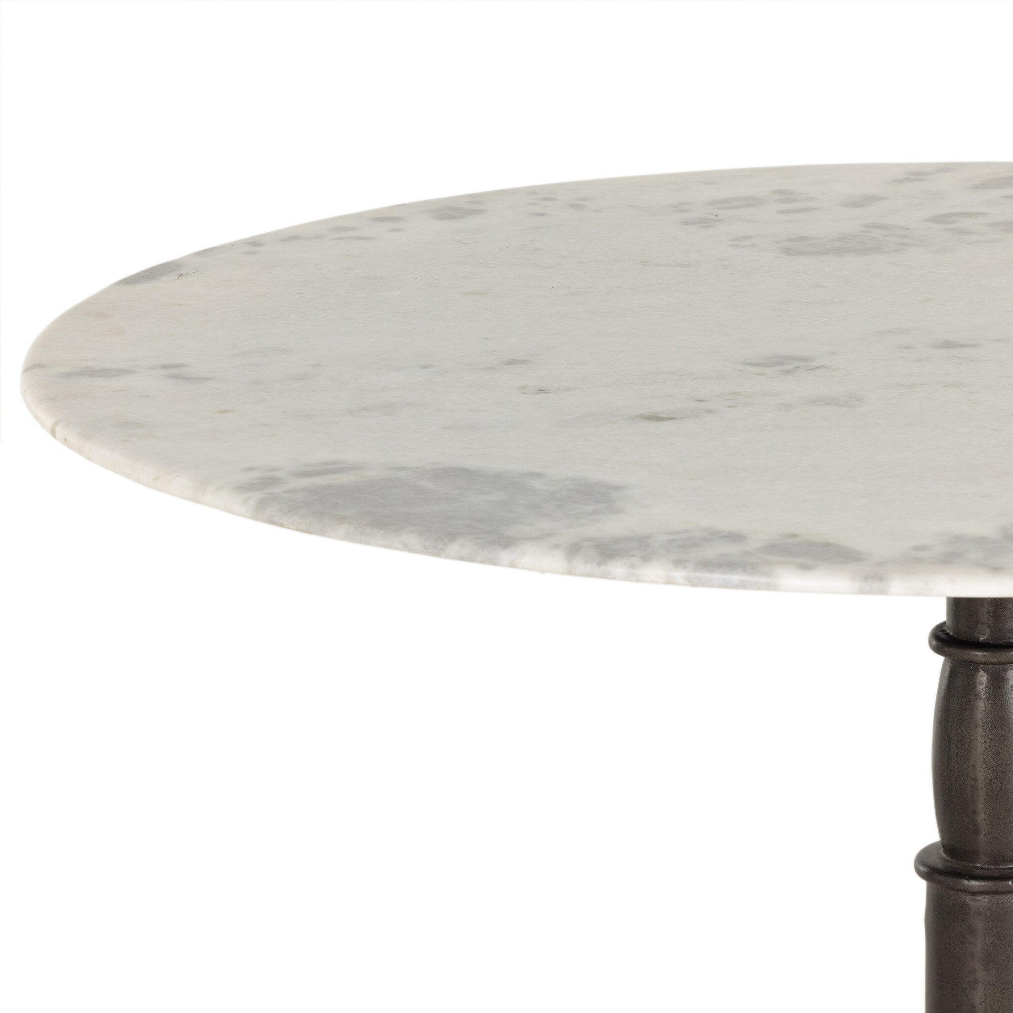 Close up of a round marble dining table with a black metal pedestal base on a white background.