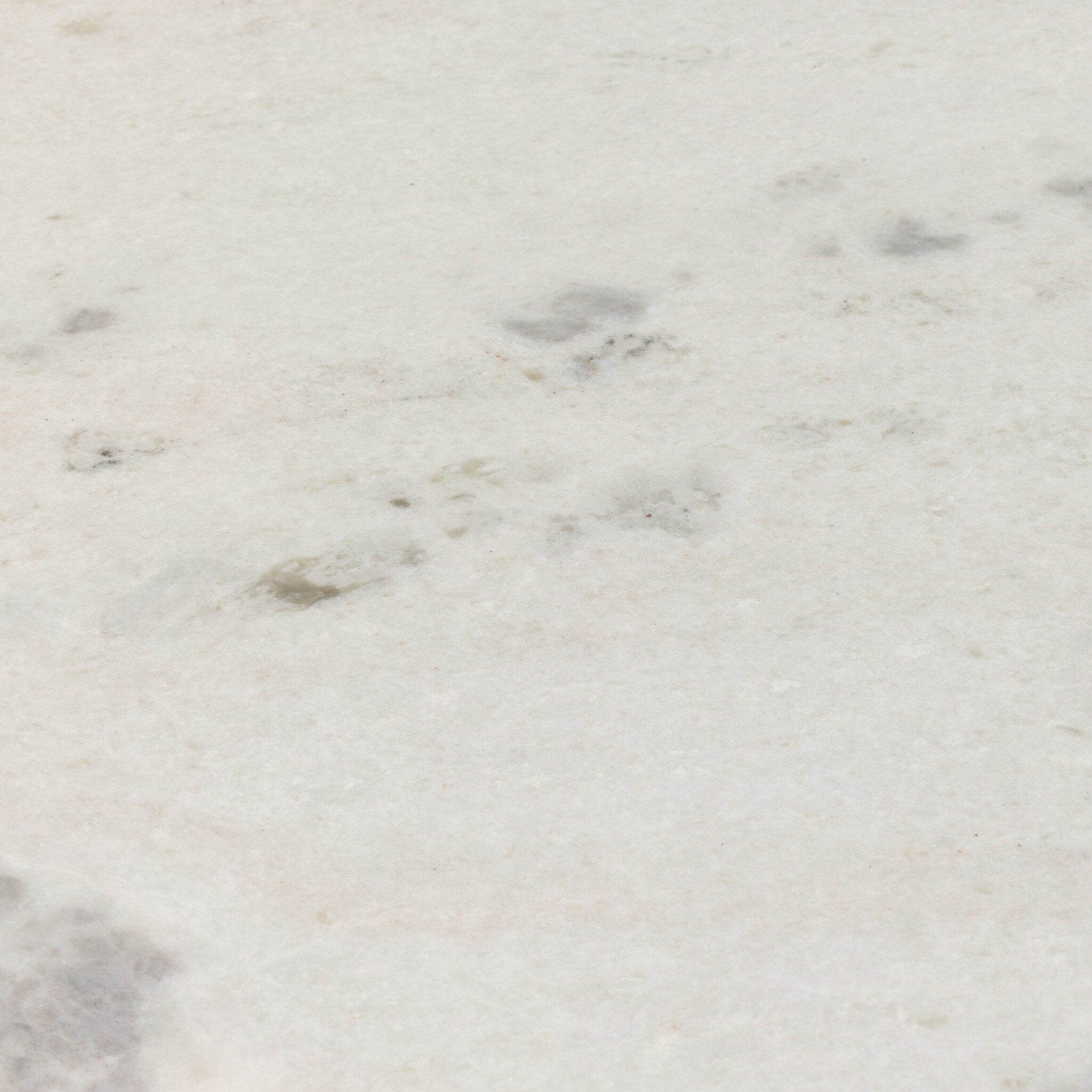 Close up of the marble top of the dining table showing its color and subtle veining.