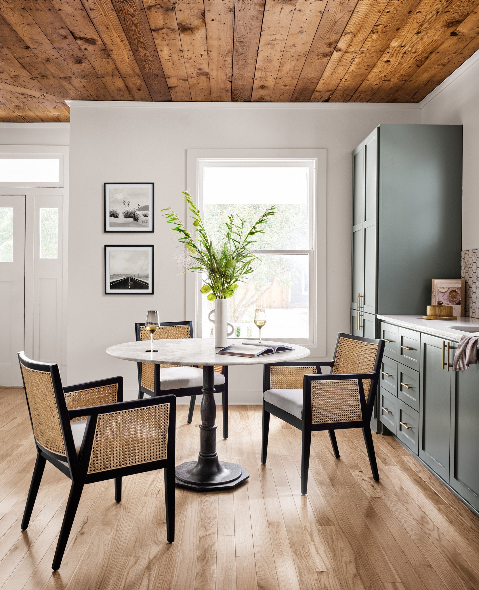 Round marble dining table with a black metal pedestal base on a white background.