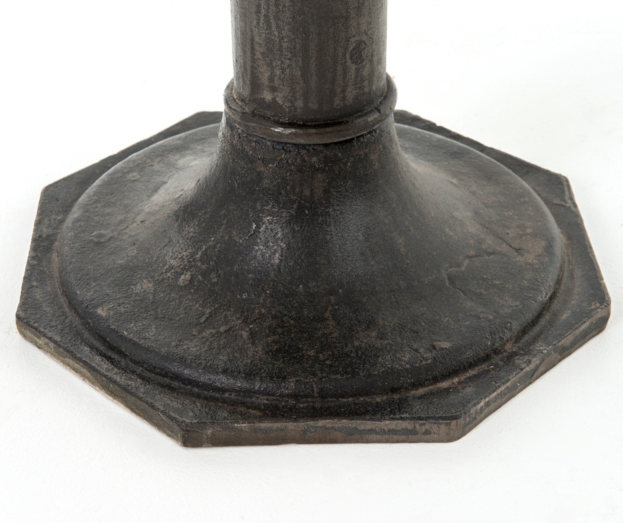 Detailed picture of a hexagonal metal pedestal table base on a white background.