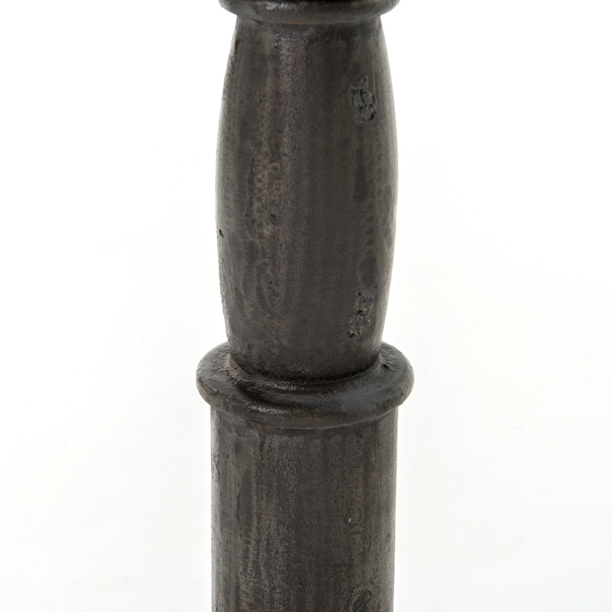 Close up picture of a metal pedestal table leg showing its detail and texture on a white background.