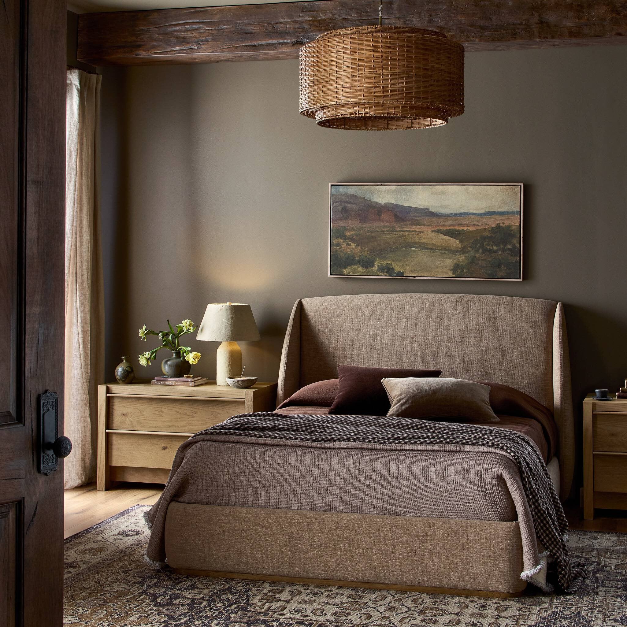 Cozy bedroom with a large bed, wooden nightstands, and a painting on the wall.