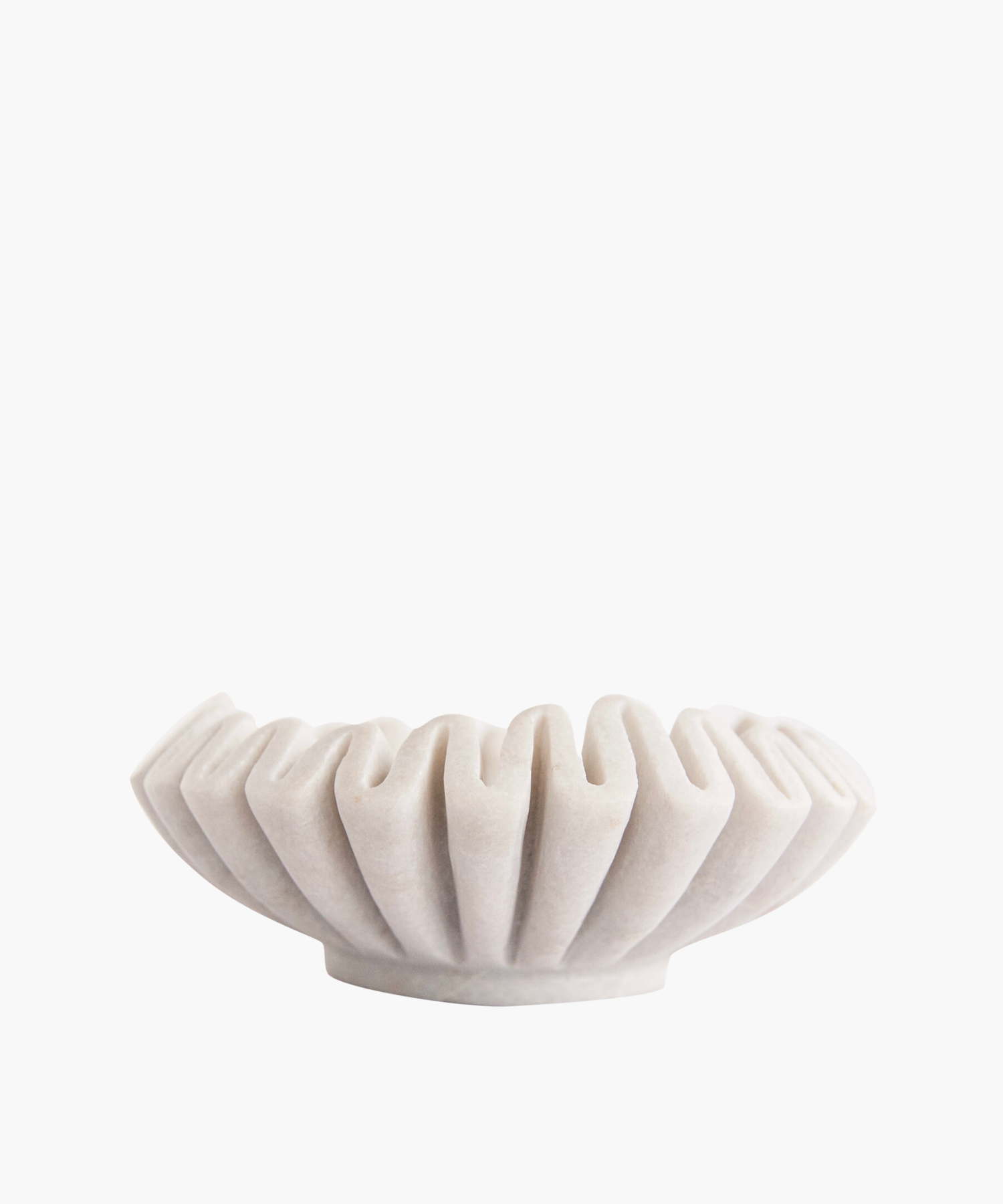Elegant white marble bowl with a pleated, fan-like design. Its sculptural form and soft shadows create a minimalist and artistic appeal.