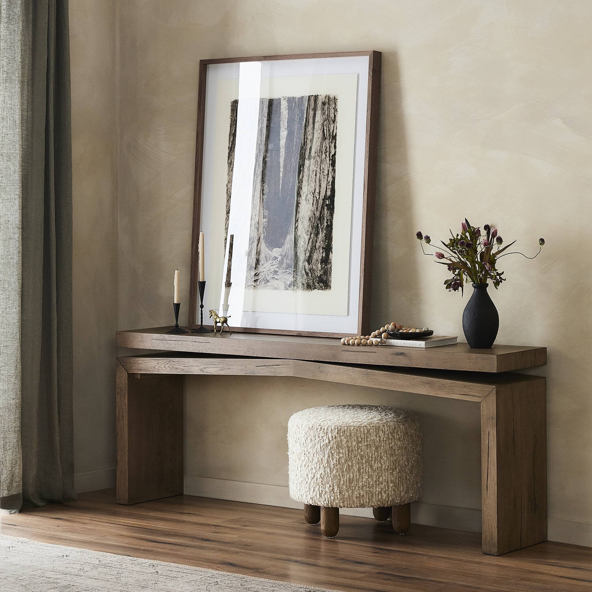 Wooden console table with decorative items against a beige wall