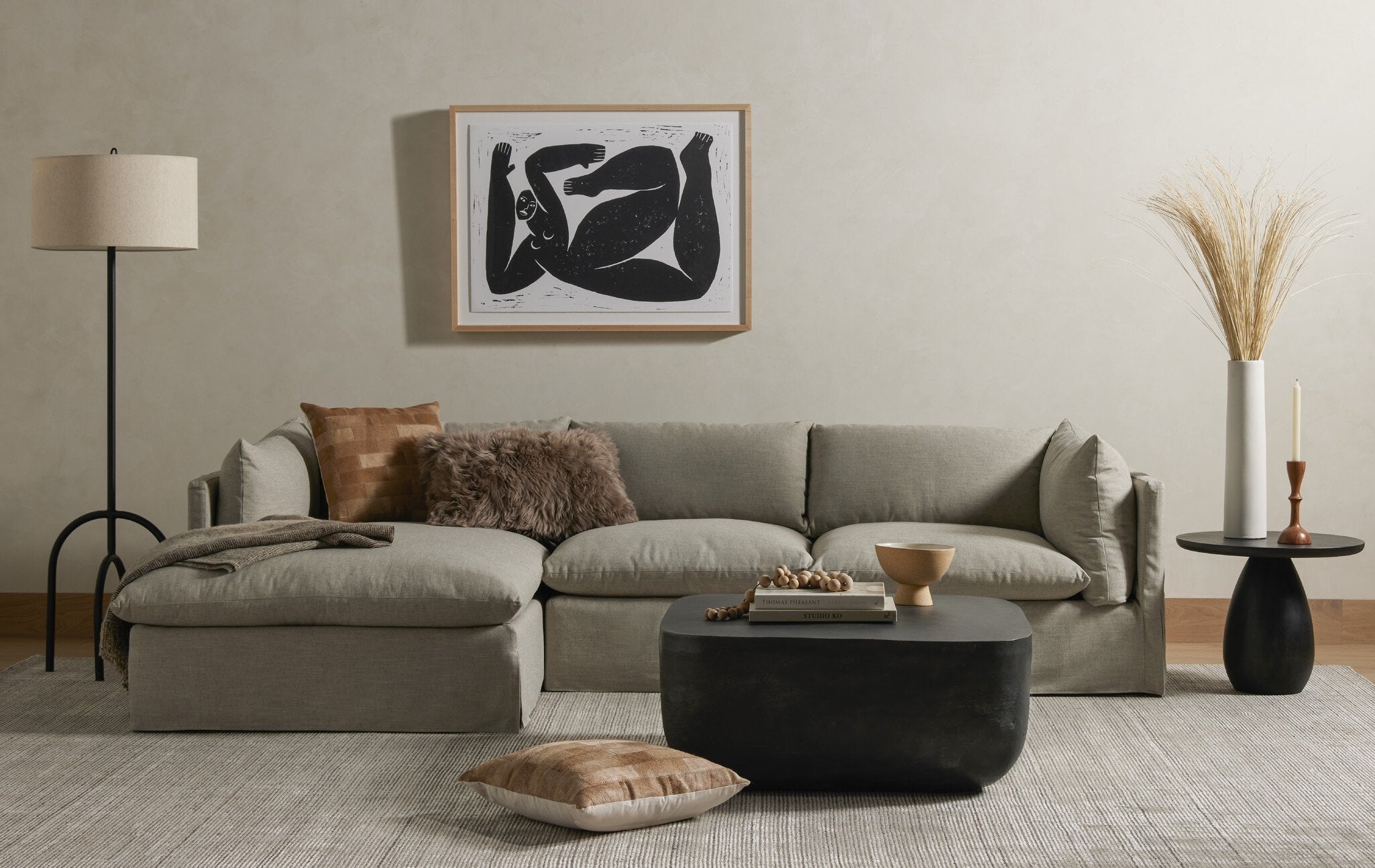 Modern living room with a gray sectional sofa, coffee table, and decorative items.