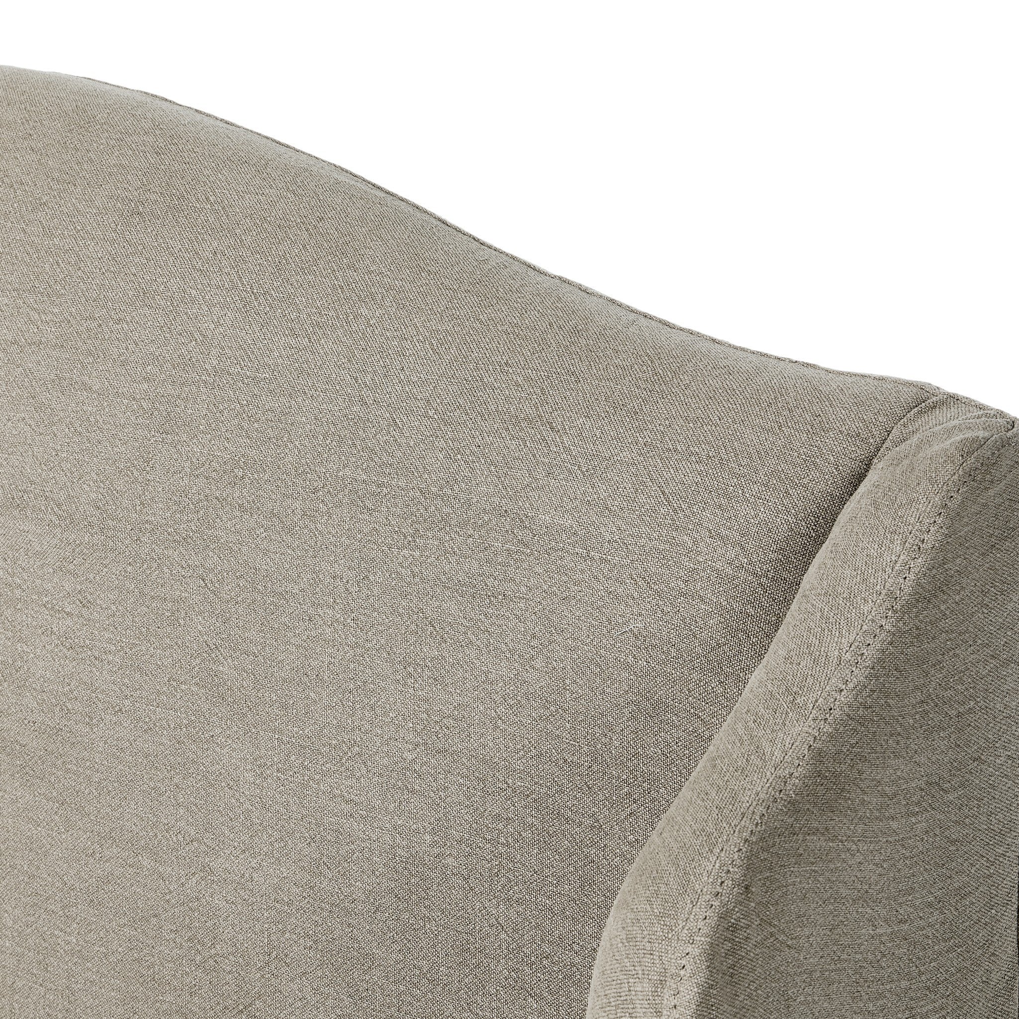 Close up of a beige upholstered bed with white bedding on a white background.