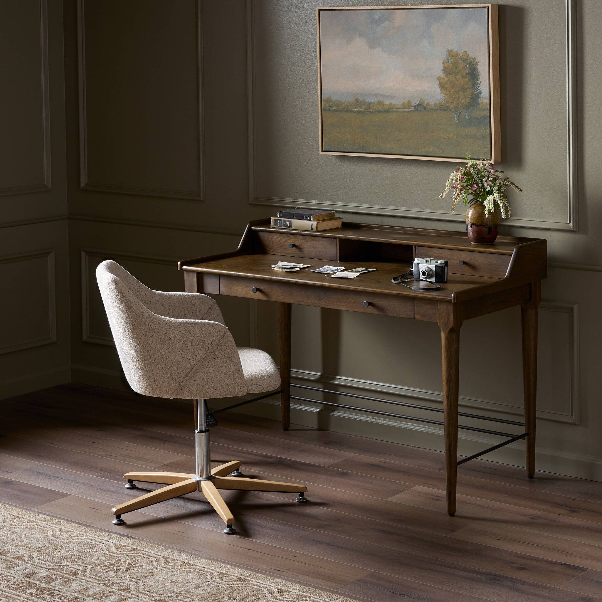 Wooden desk with chair in a room with a painting on the wall