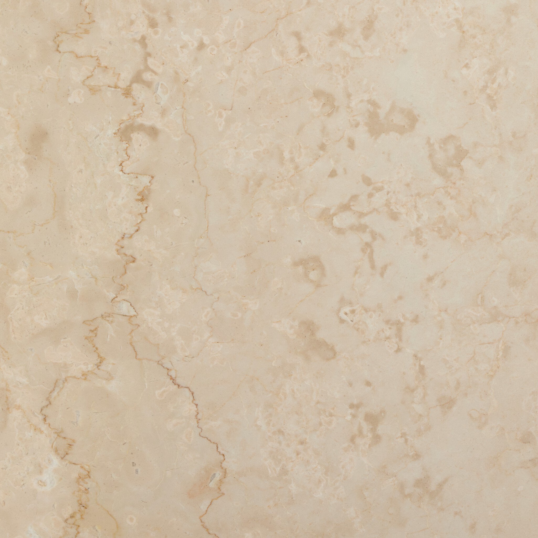 Close up view of a square beige marble end table showing its color and veining.