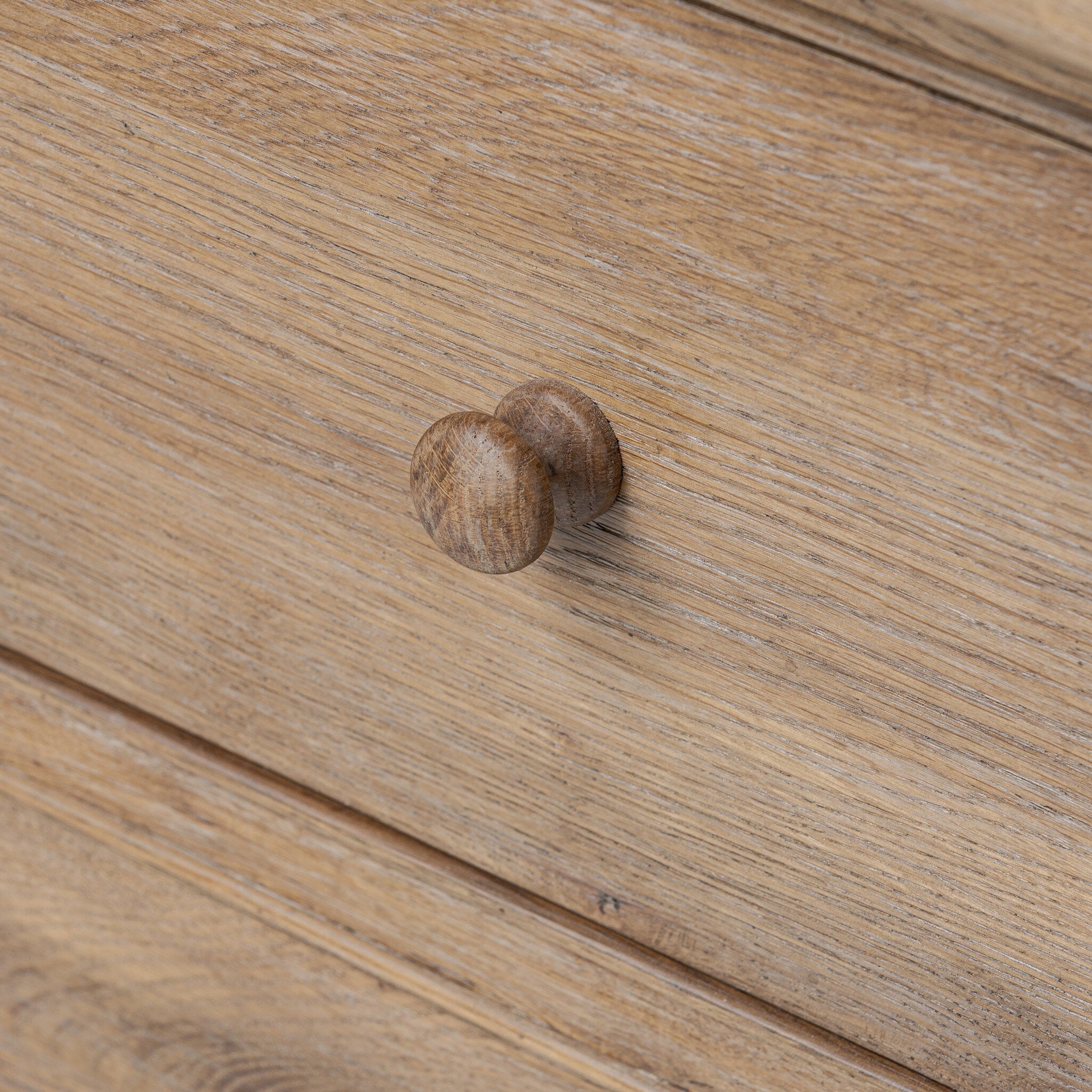 Close up of a wooden drawer with a knob on a wooden surface.