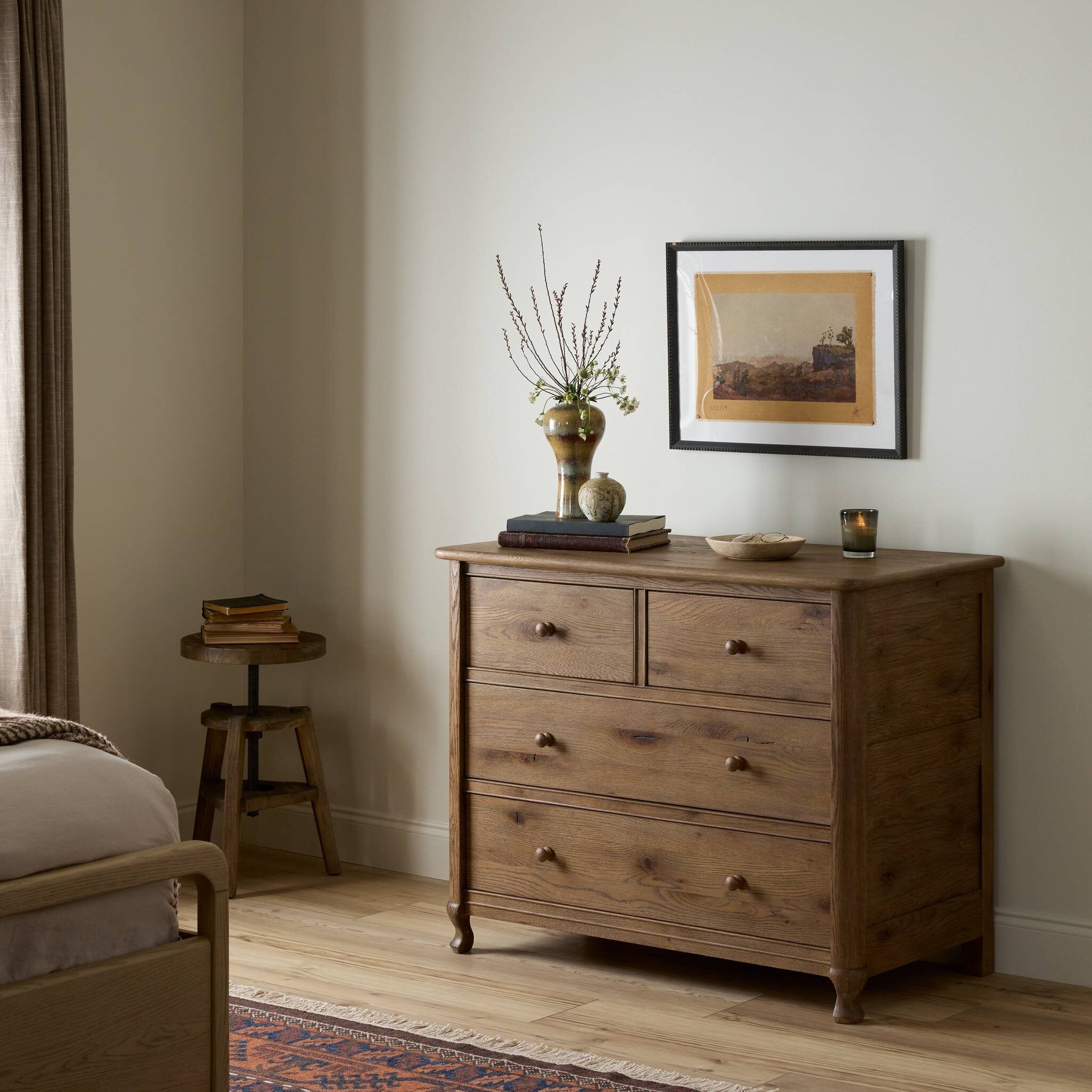 Wooden dresser with decorative items in a bedroom setting