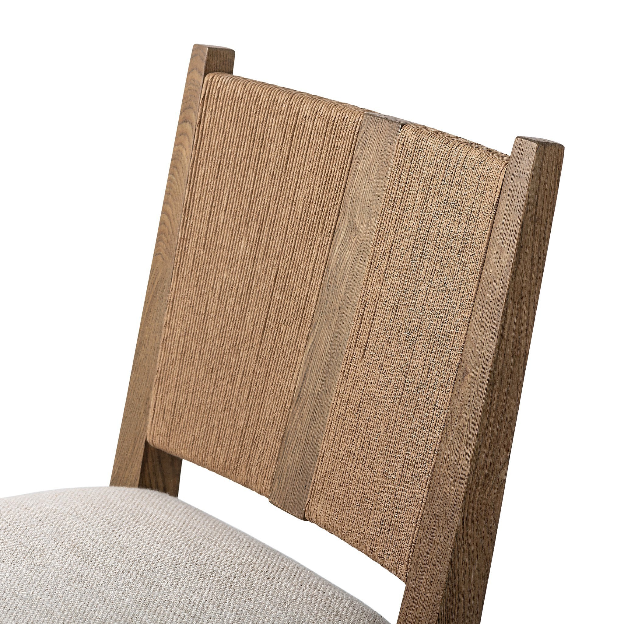 Wooden dining chair with a woven backrest and white cushion on a white background