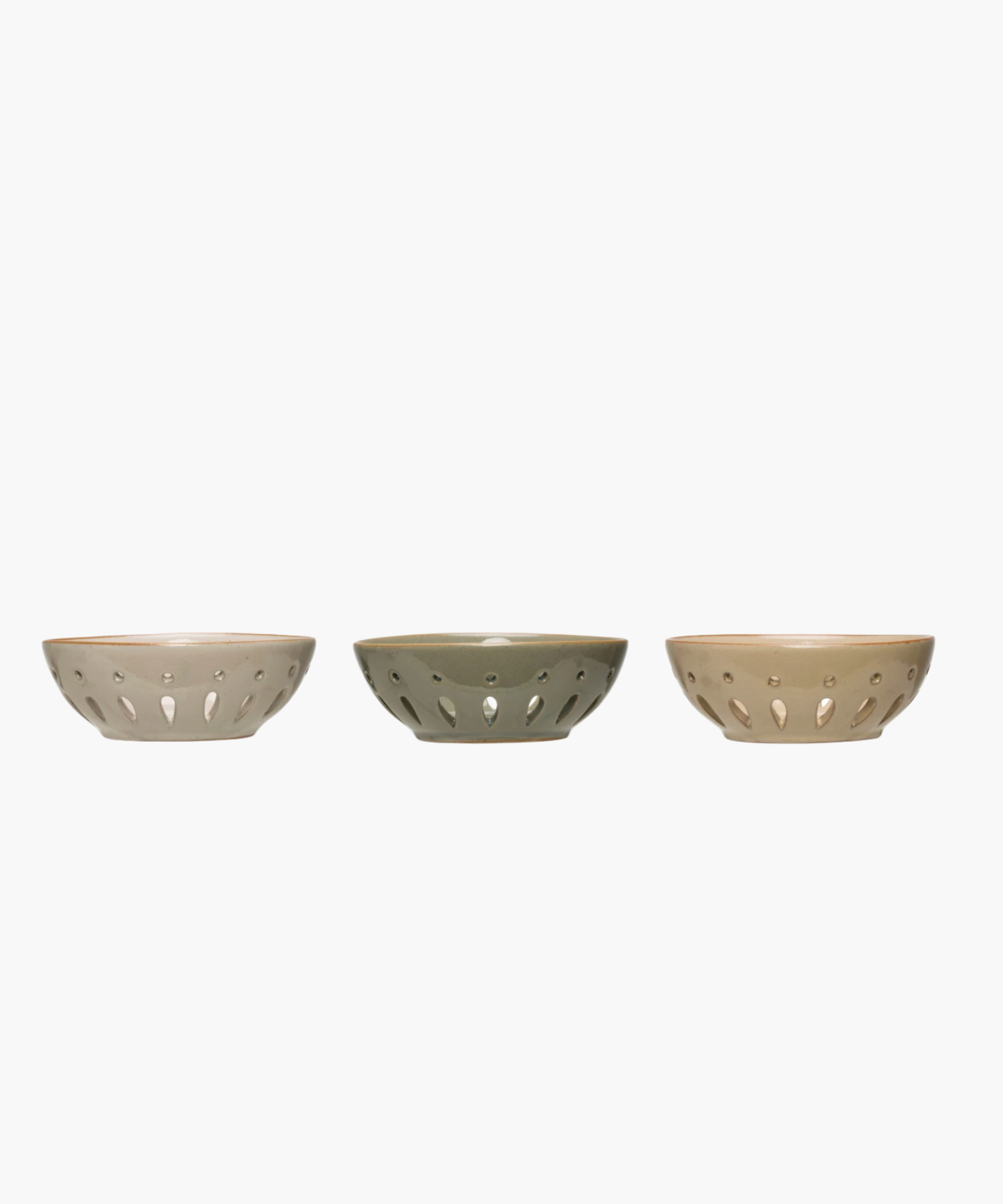 Side profile of three colanders in muted beige and gray tones are evenly spaced in a row. Each has a sleek, modern design with decorative cutout patterns.
