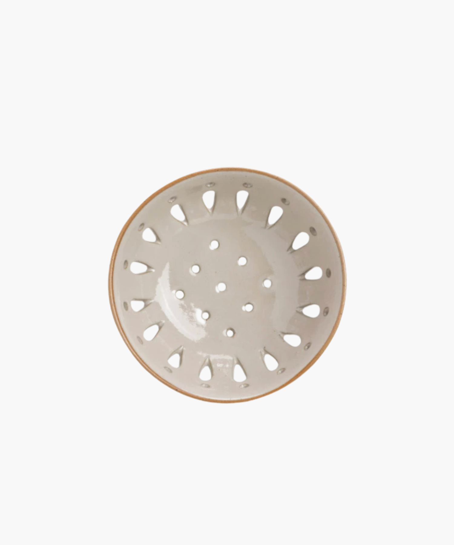 A beige ceramic colander with a light brown rim, featuring round holes and teardrop-shaped cutouts, standing out against a plain white background.