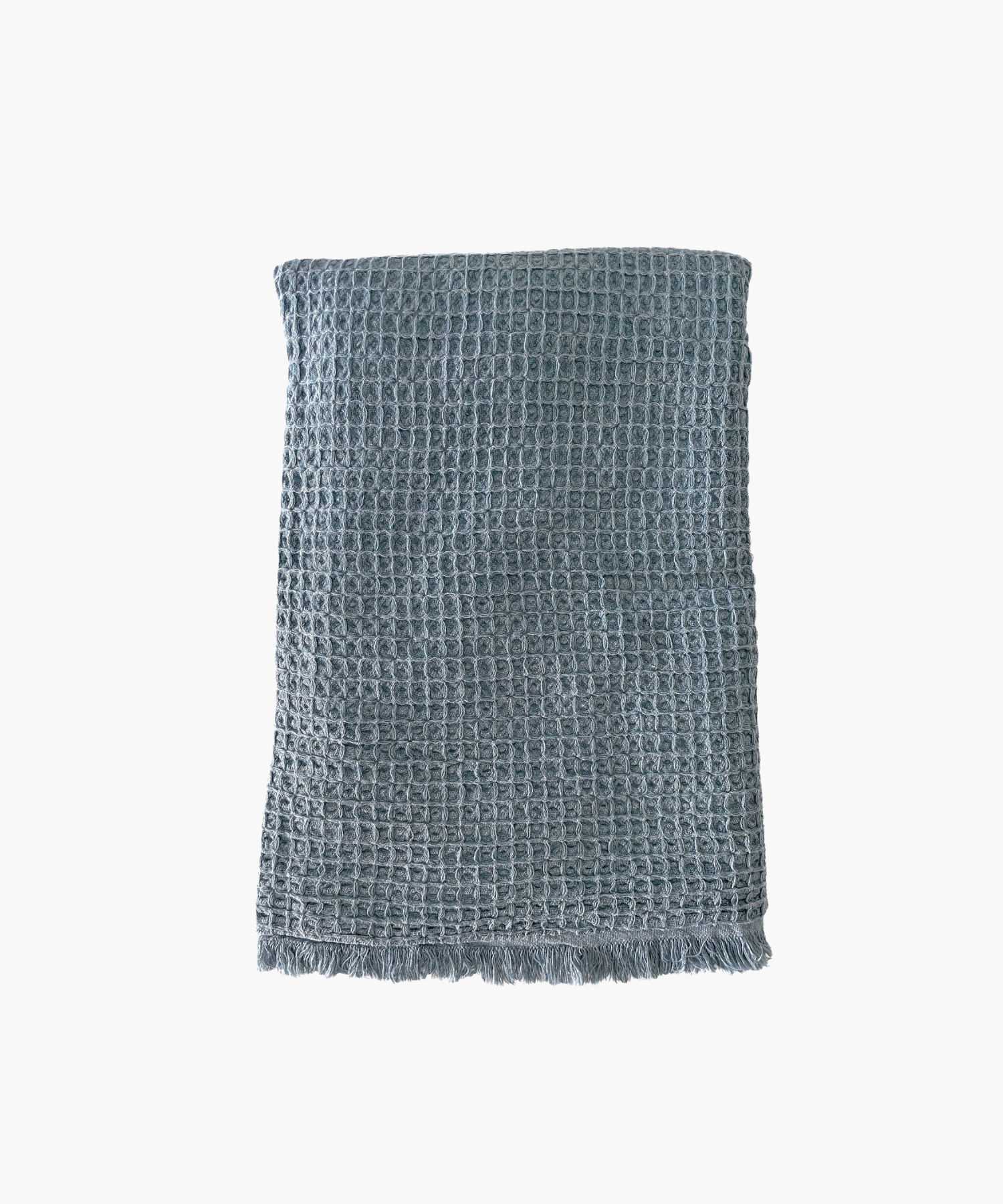Vintage blue waffle-textured throw blanket with fringed edges, laid flat. The soft material conveys a cozy, inviting feel. Suitable for any living room or bedroom.