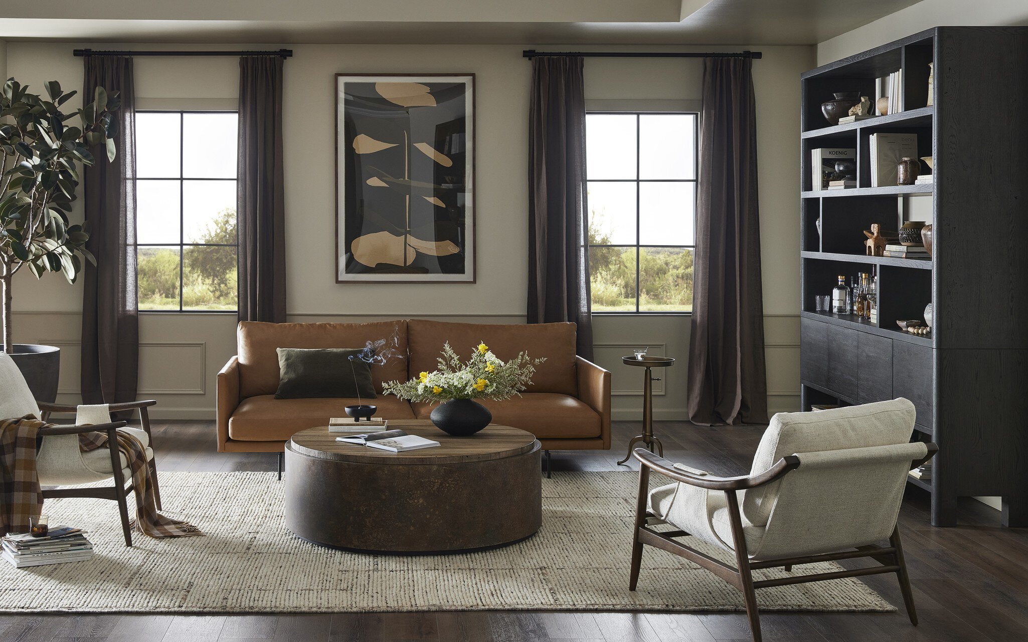 Living room with brown sofa, round coffee table, and white armchair.